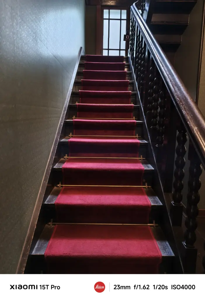 Xiaomi 15T Proで撮影した赤絨毯の階段と木製手すり（23mm超高感度ISO4000作例）