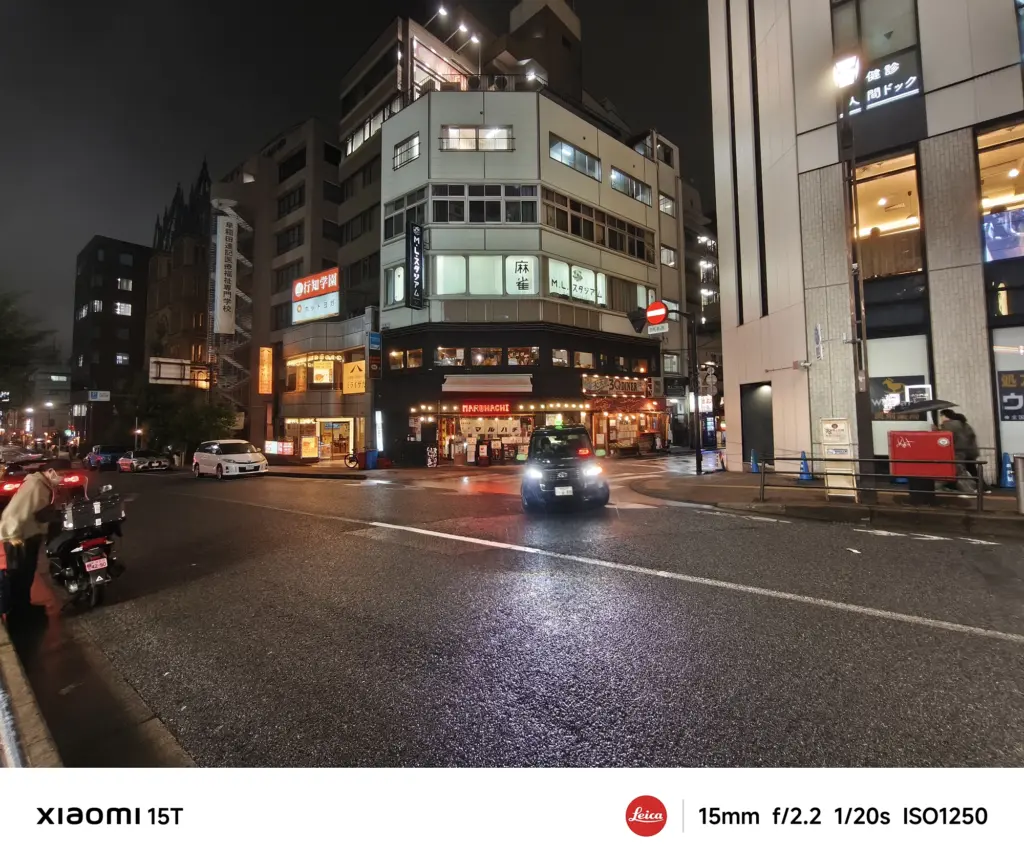 Xiaomi 15Tの超広角カメラで撮影した夜の街角。車のライトと建物の灯りが映り込み、リアルな臨場感を再現した作例