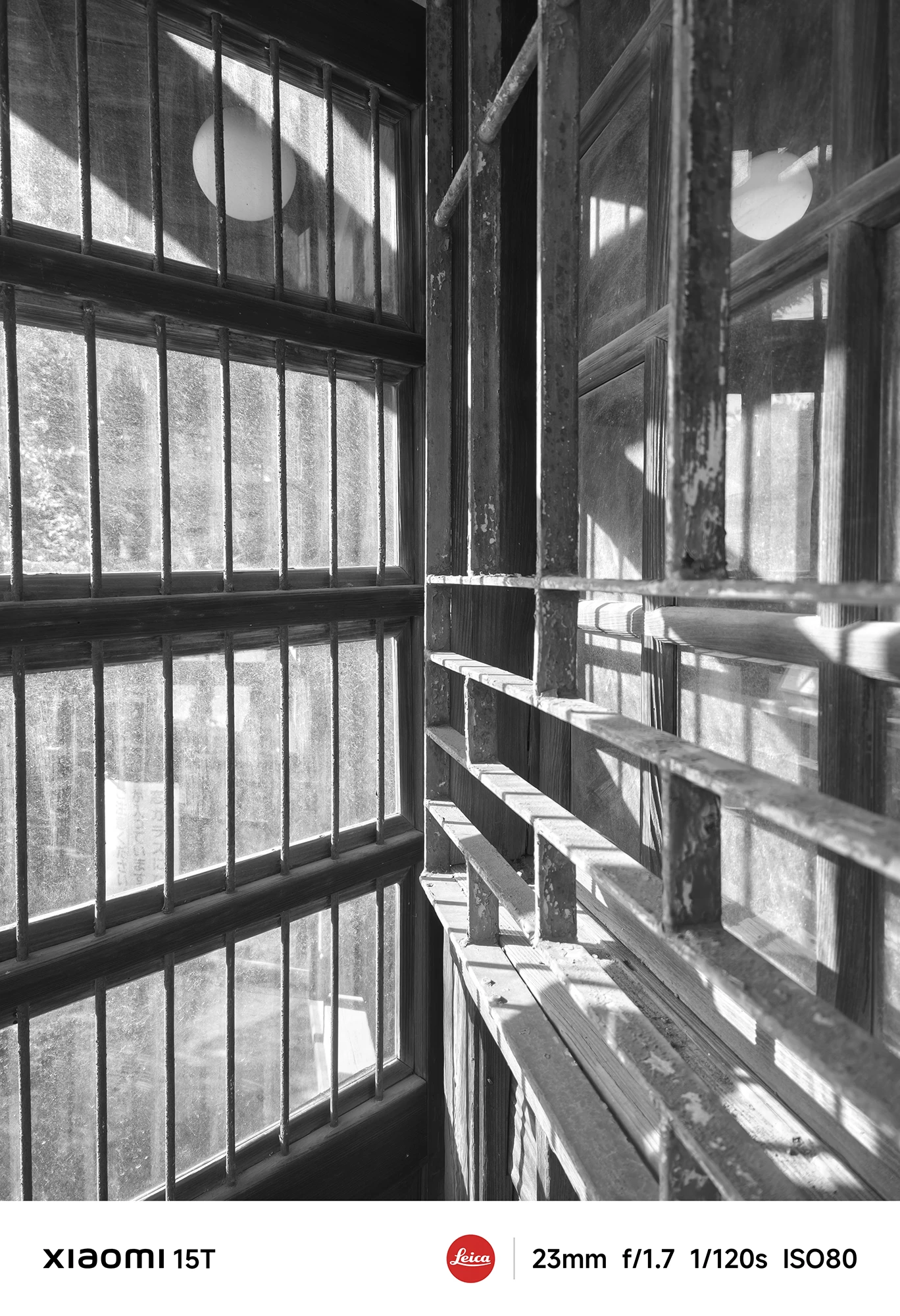 Xiaomi 15TのLeicaモノクロフィルターで撮影した格子窓。柔らかな光と影が交錯し、古建築の静けさをモノクロで美しく表現