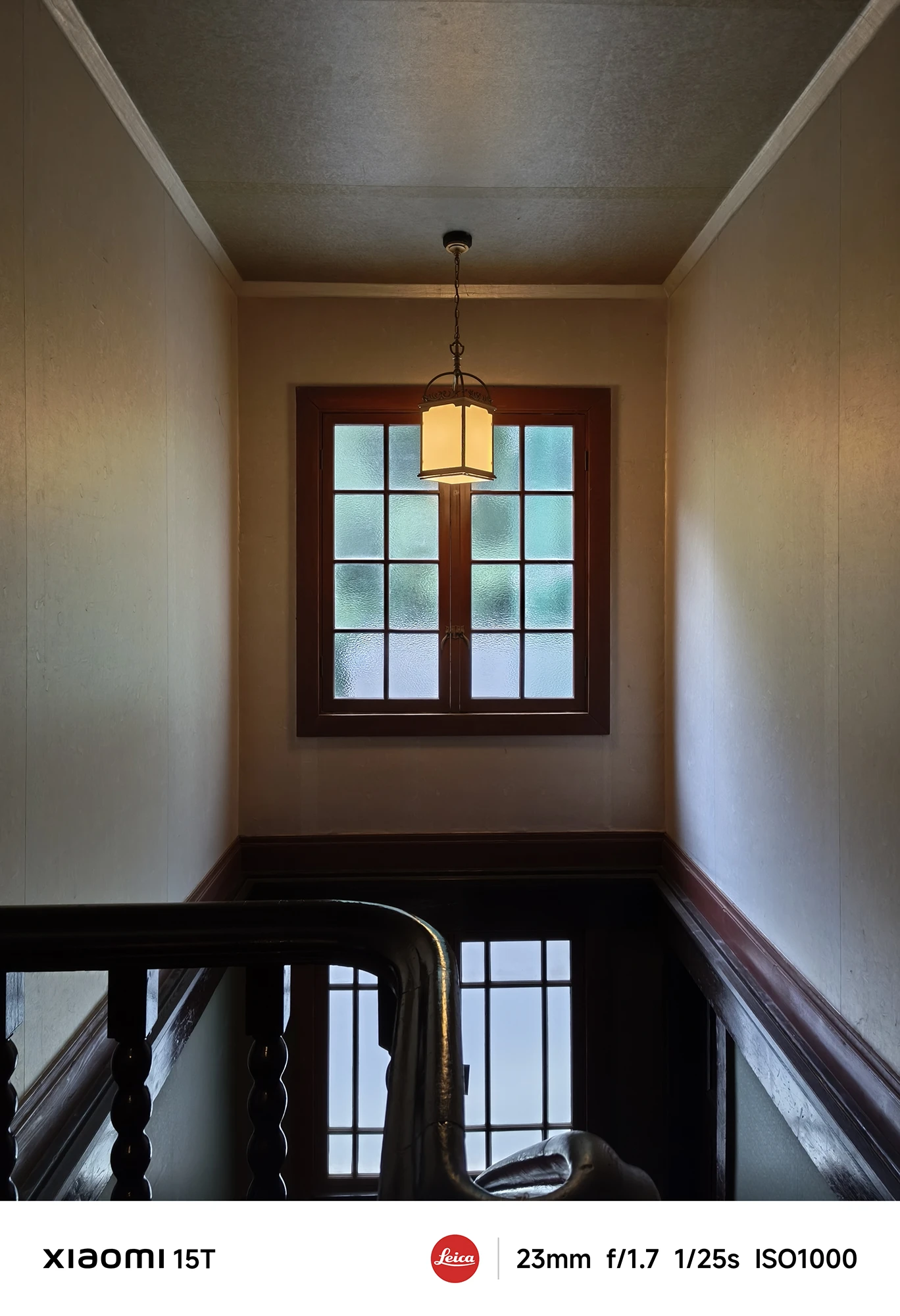 Xiaomi 15Tのメインカメラで撮影した階段と木枠の窓。自然光を生かした陰影表現が印象的な洋風建築の室内写真