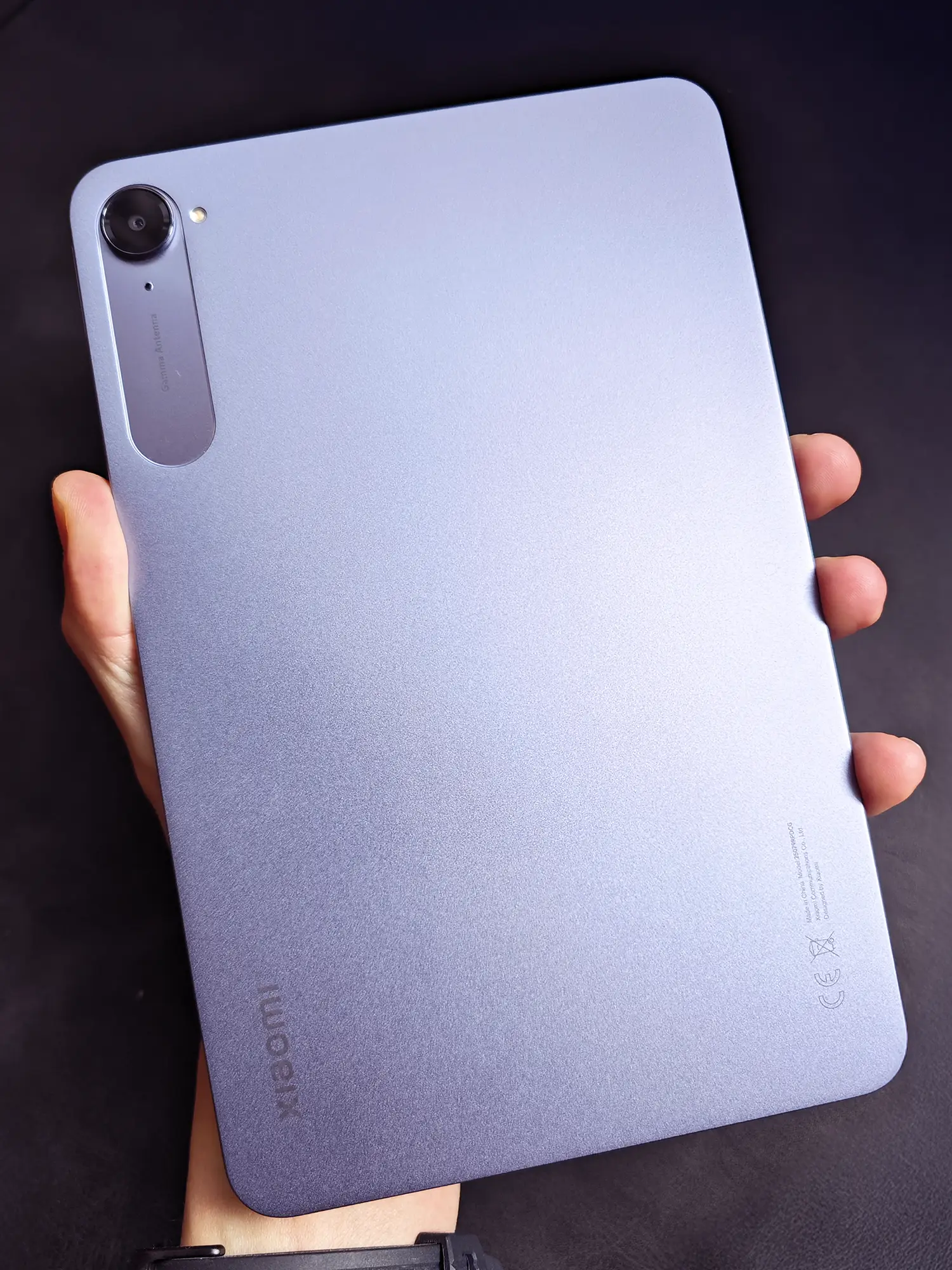 Xiaomi製タブレット(パープル/ブルーグレー)の背面を手に持っている写真。マットな質感とコンパクトなサイズ感、メインカメラとGamma Antennaのデザインが確認できる。