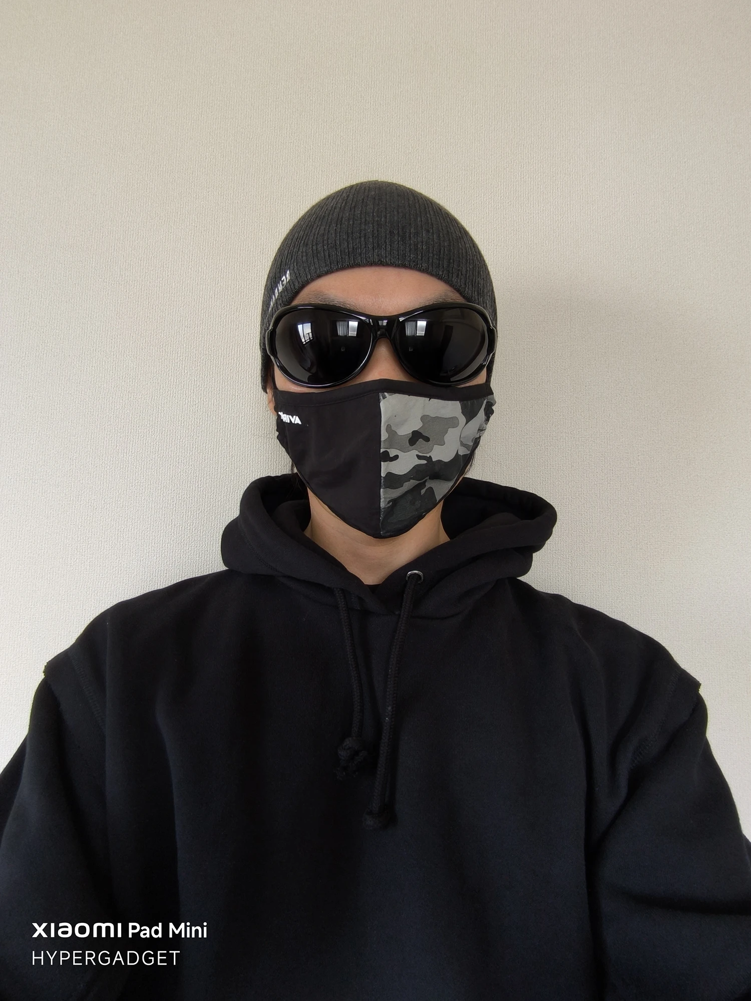 Xiaomi Pad Miniで撮影された、サングラスとニット帽、迷彩マスクを着用した人物の正面ポートレート写真。