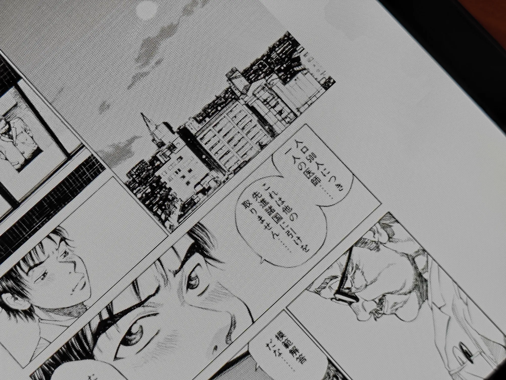 電子書籍リーダー(タブレット)でマンガのページを表示しているクローズアップ。モノクロで鮮明な活字とコマ割りが確認できる、電子コミックの読書シーン。