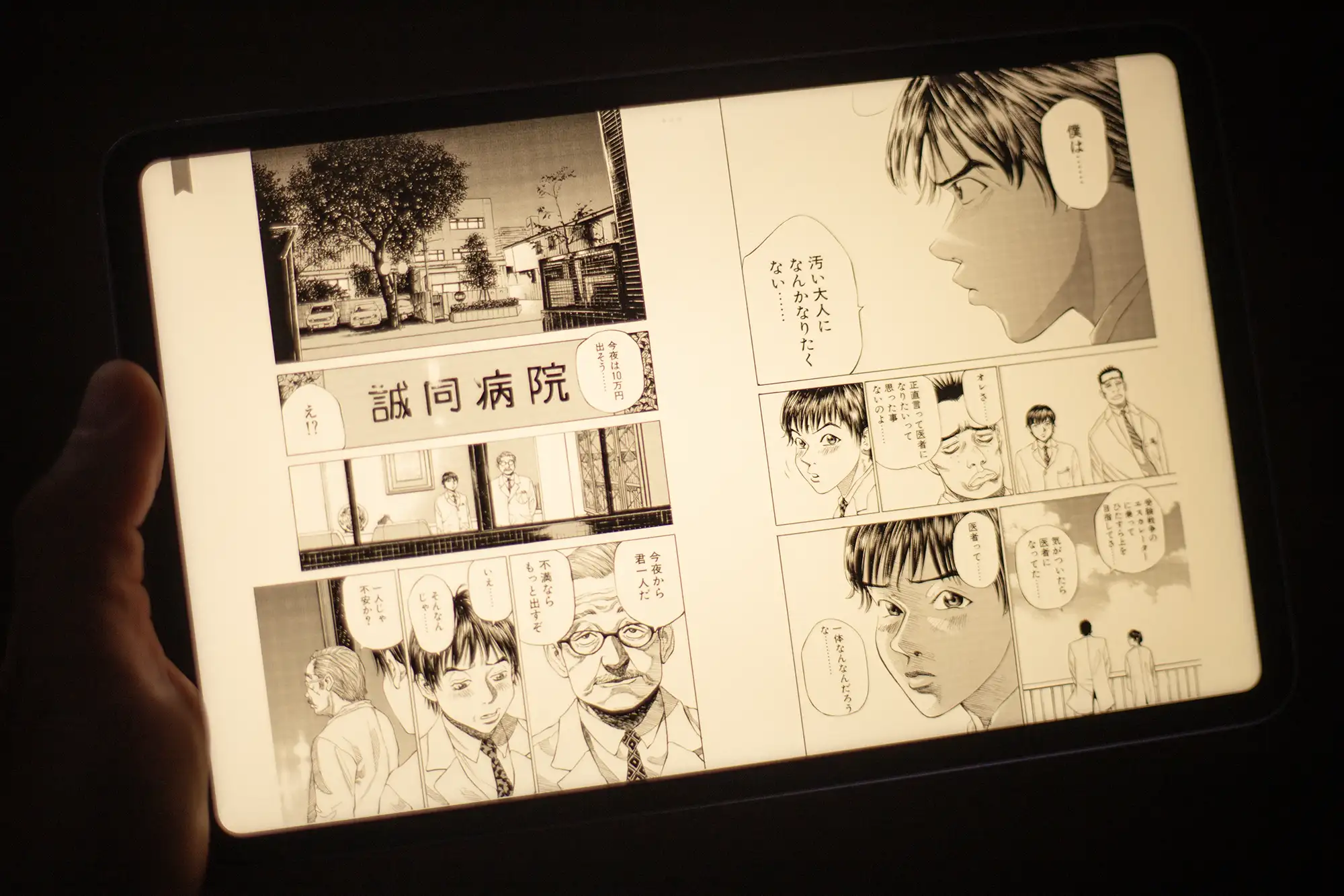 電子書籍リーダー(タブレット)でマンガを見開き表示している読書シーン。画面の色温度が暖色(黄色)に設定され、読書モードで目の負担を軽減している状態。