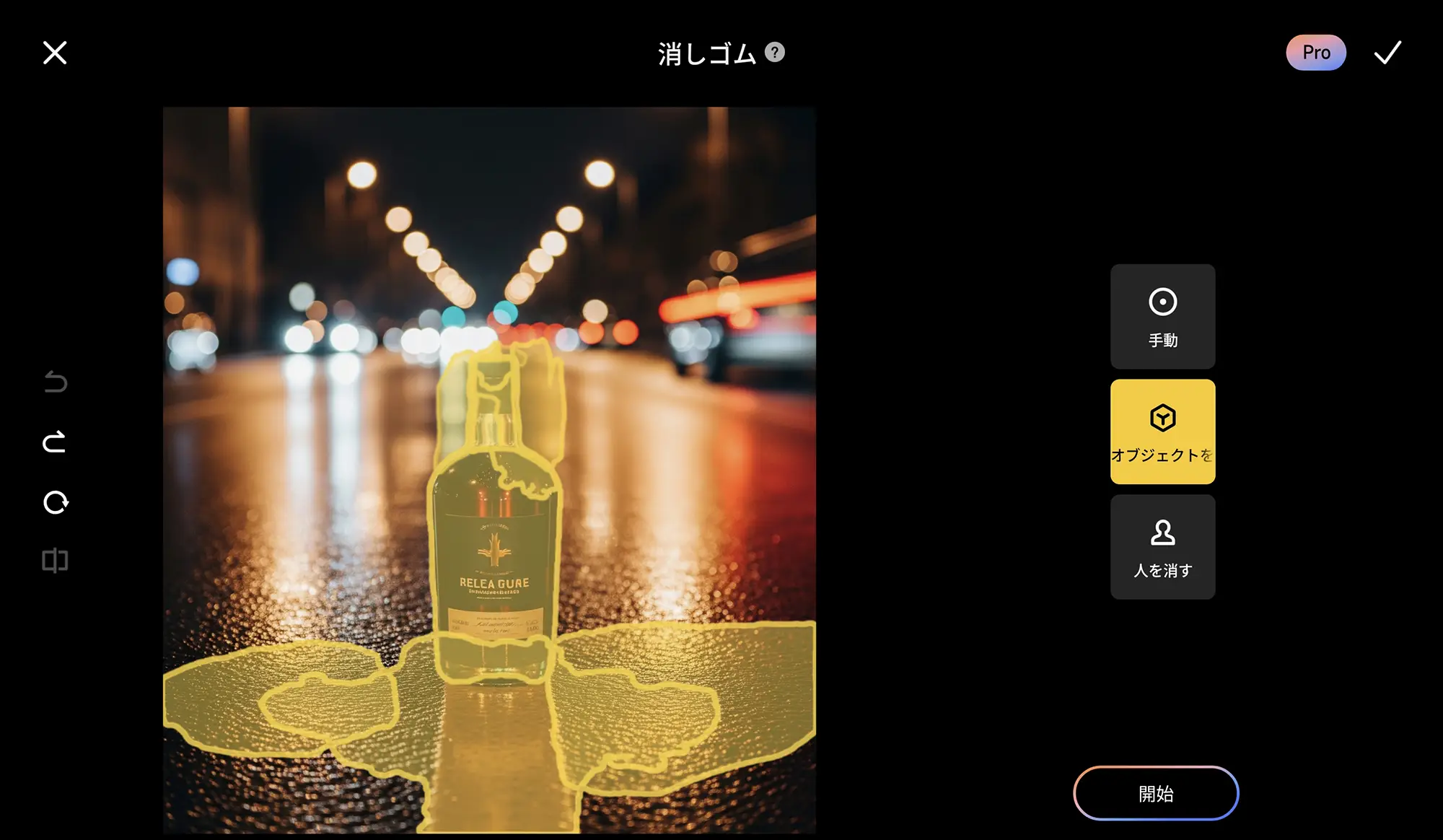 夜の道路の中央に置かれたガラス瓶を自動選択しているスマートフォンの消しゴムツールの画面。背景にはボケた車のライトが連なり、黄色い線で瓶とその反射部分が囲まれている。
