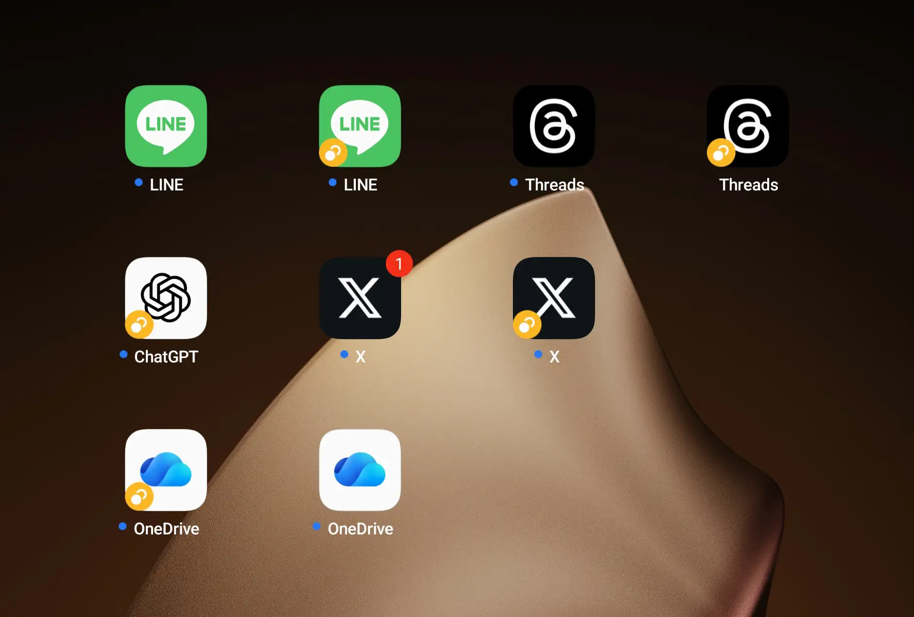 スマートフォン(タブレット)のホーム画面。デュアルアプリ機能により、LINE、Threads、X(旧 Twitter)、OneDriveなど複数のアプリのアイコンが複製され、二つのアカウントが利用可能になっている様子。