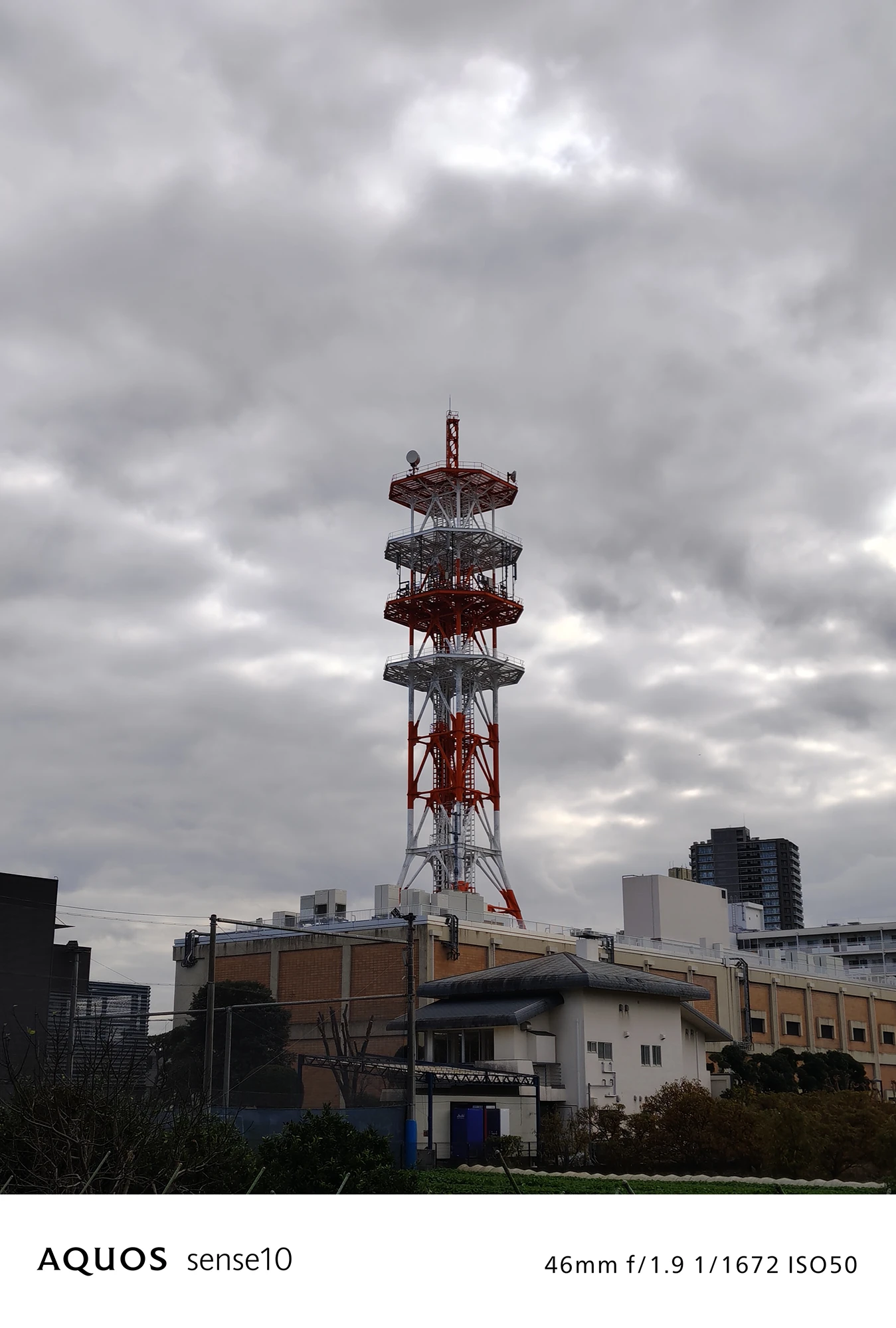 AQUOS sense10撮影サンプル：2倍ズームで捉えた都市風景と鉄塔の圧縮効果（f/1.9 ISO50）