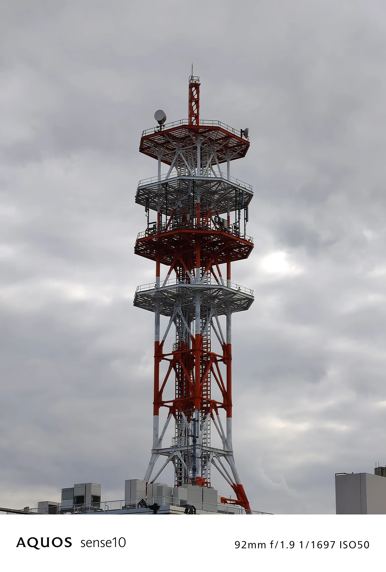 AQUOS sense10撮影サンプル：2倍ズームで捉えた**赤白の通信塔**（f/1.9 ISO50）