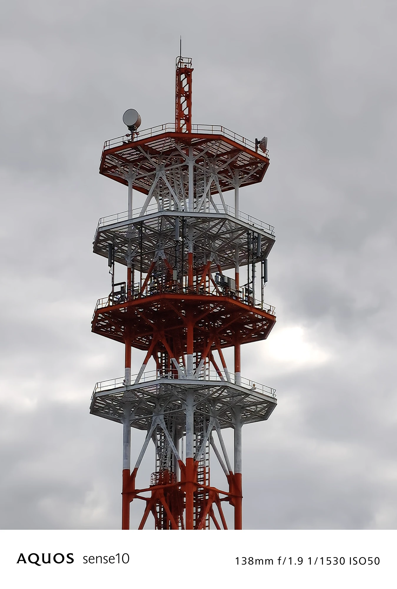 AQUOS sense10撮影サンプル：3倍ズームで捉えた**赤白の通信塔上部の詳細**（f/1.9 ISO50）