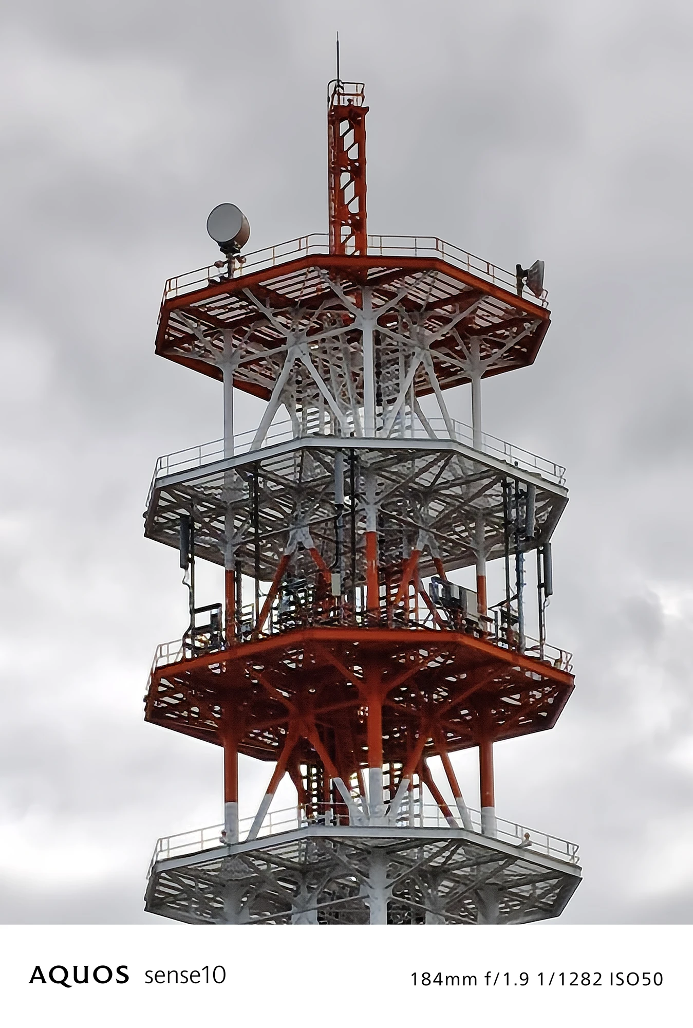 AQUOS sense10撮影サンプル：4倍ズームで捉えた**赤白の通信塔頂上部の詳細**（f/1.9 ISO50）