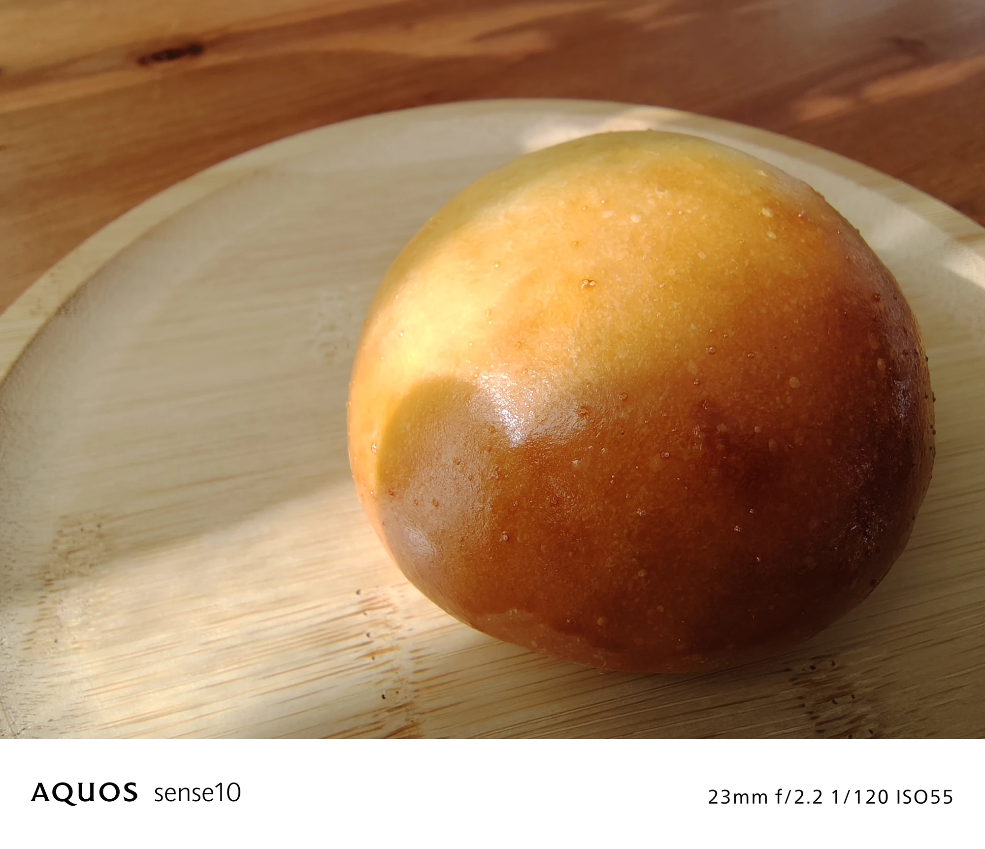 AQUOS sense10 撮影サンプル　丸いパンと木皿（クローズアップ、料理）23mm f/2.2 1/120 ISO55