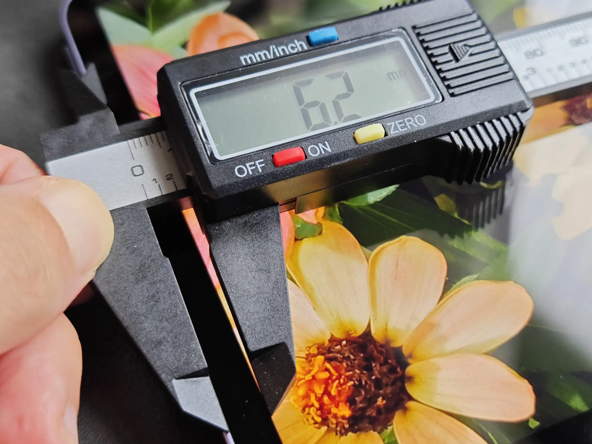 デジタルノギスでタブレットのベゼル幅を計測。ディスプレイ外側の額縁幅が$6.2\text{ mm}$と測定されている写真。