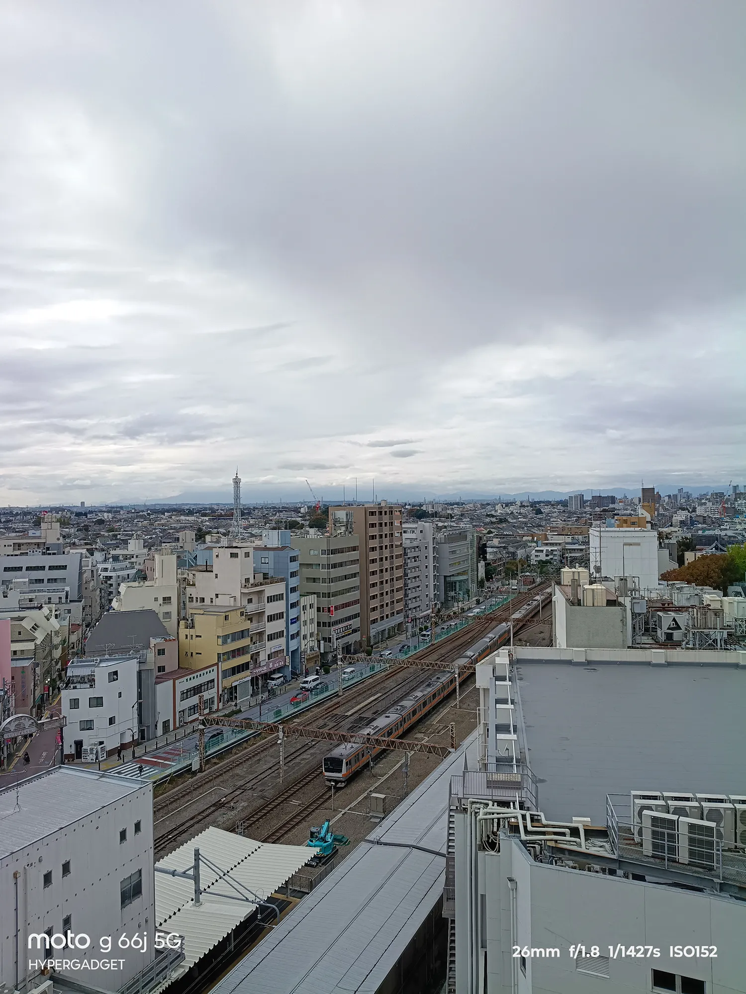moto g66j 5Gのカメラ作例：高層階から見下ろした広大な都市の町並みと線路を走る電車（武蔵野線/京葉線）