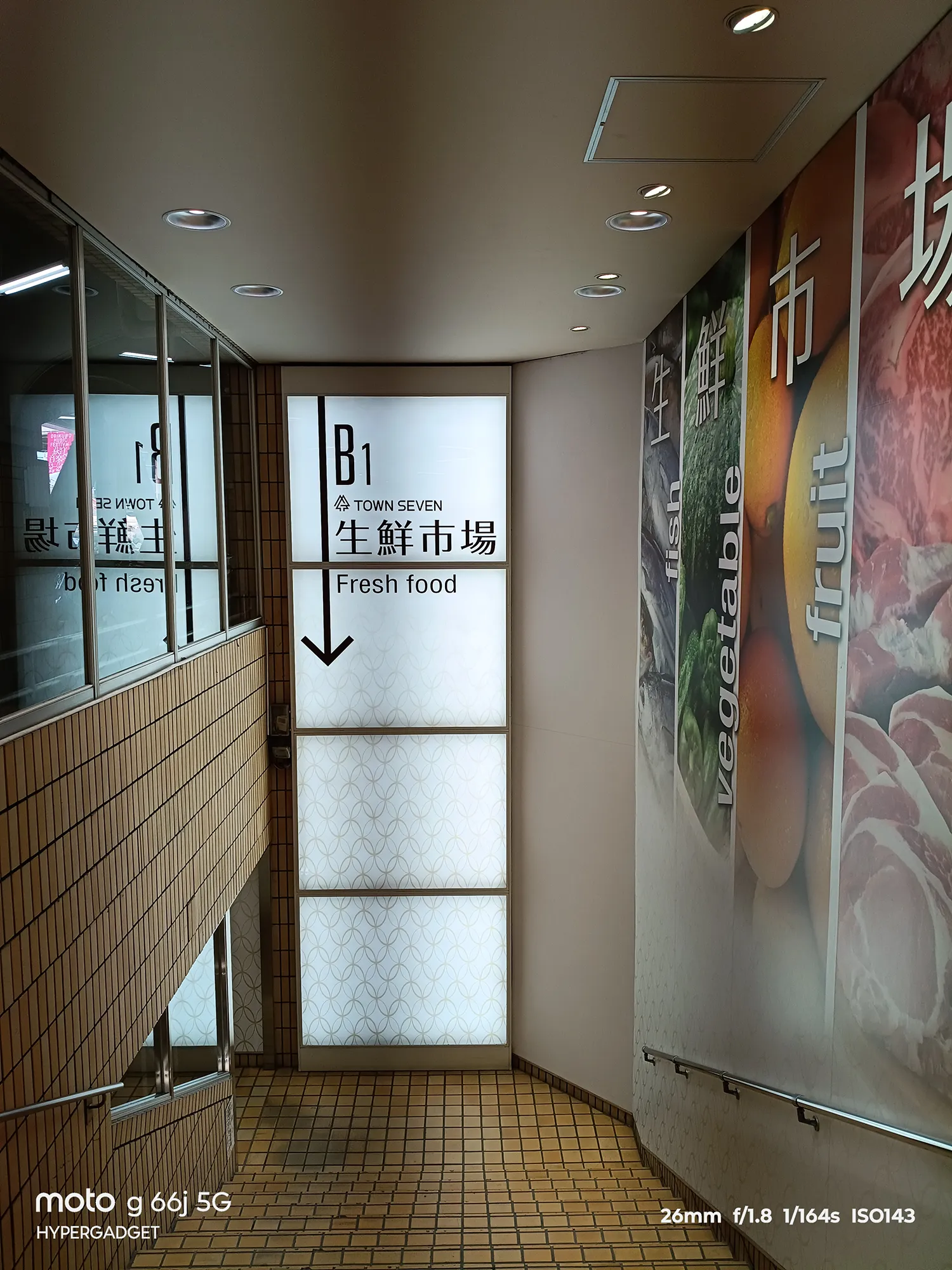 moto g66j 5Gのカメラ作例：生鮮市場への案内看板がある商業施設の地下階段。屋内や低照度下での画質をレビュー