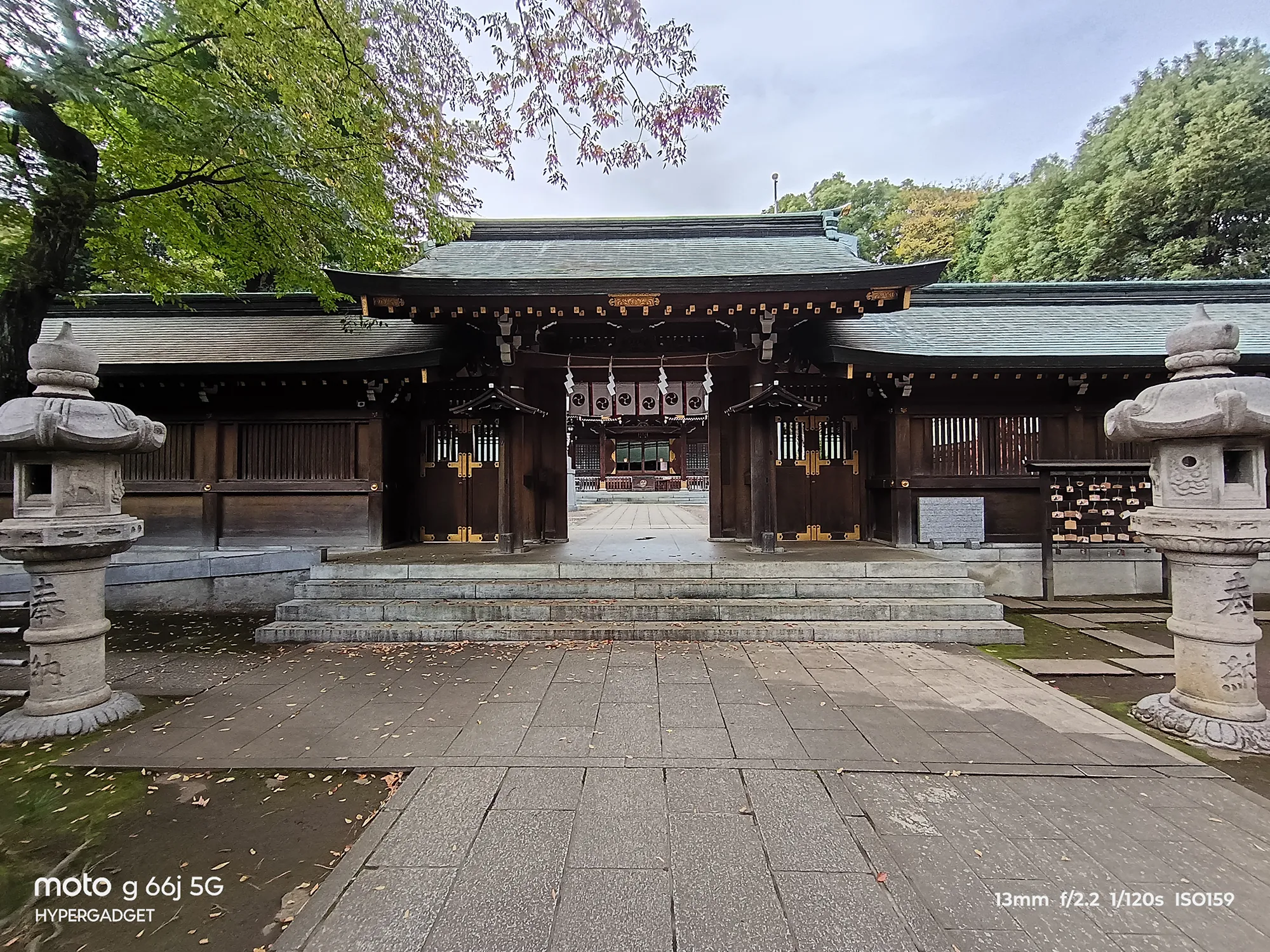 moto g66j 5Gの超広角カメラ作例：石灯籠の間に見える神社の門と拝殿を撮影。広範囲の建物描写と石材の質感をレビュー