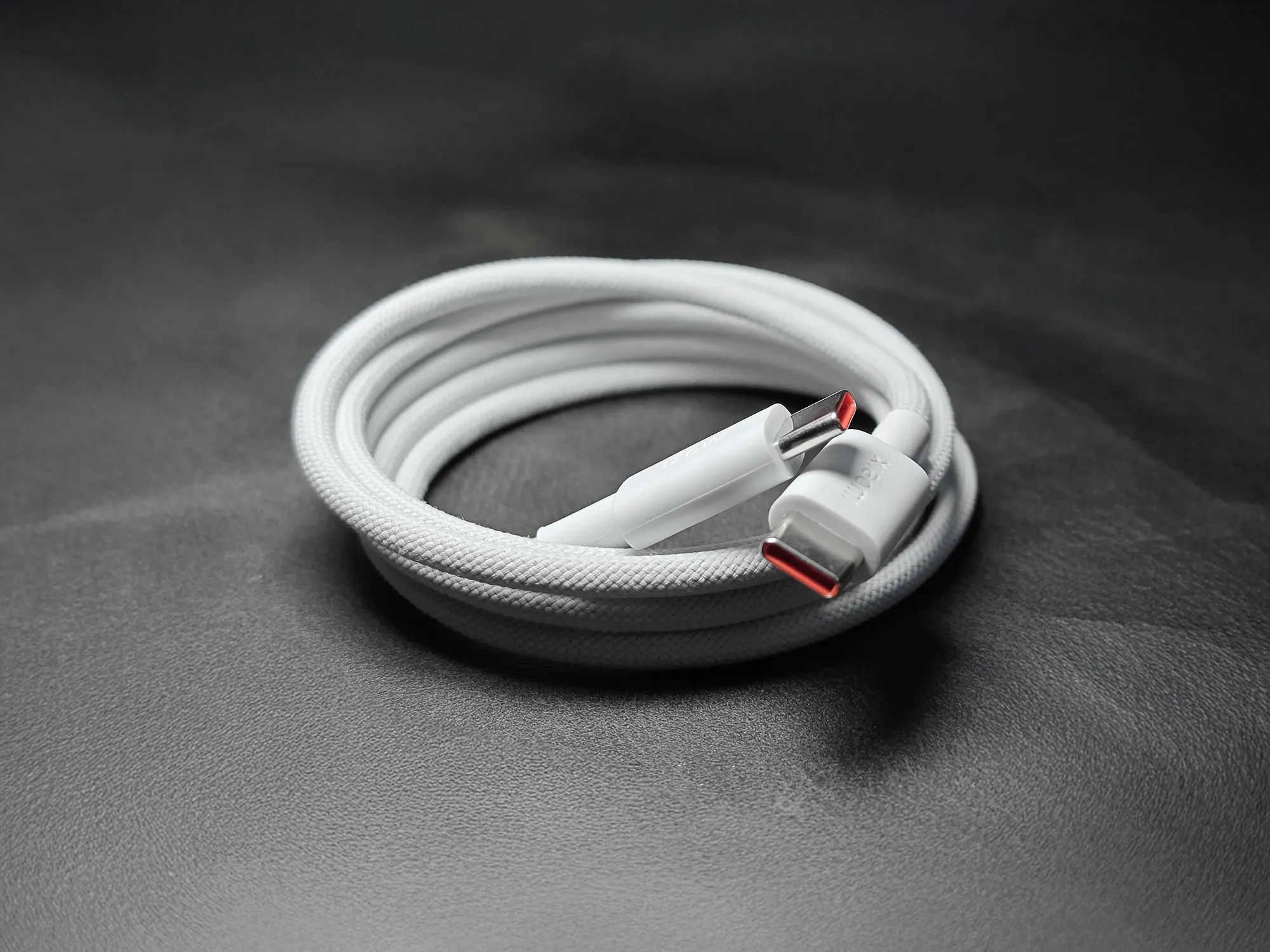 Xiaomi (シャオミ) 製のUSB-C to USB-C 編み込みケーブルが巻かれた状態の画像。コネクタ内部がオレンジ色に見える。