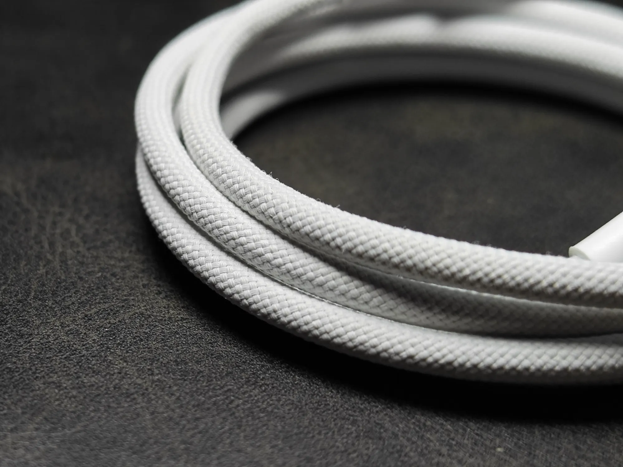 白い編み込み (Braided) 仕様のUSBケーブルのクローズアップ画像。ケーブルの丈夫な質感と素材感が確認できる。