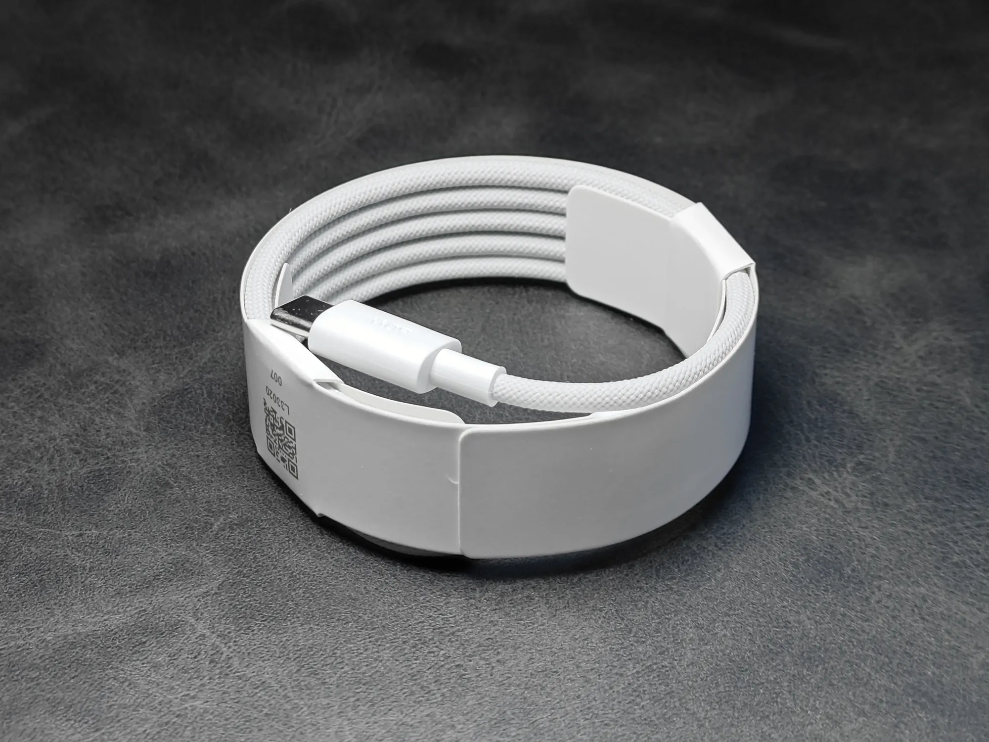 Xiaomi (シャオミ) 製のUSB Type-C to Type-C ケーブル。白い編み込みケーブルが結束バンドで巻かれた状態で、コネクタ部分が見えている。