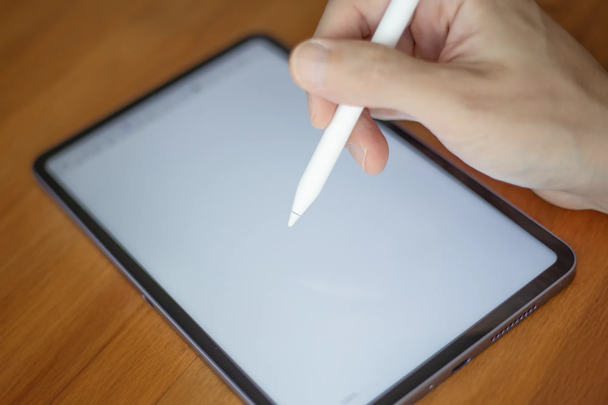 白いスタイラスペン(タッチペン)を使ってタブレットの画面に書き込み(筆記/描画)をしているクローズアップ写真。スタイラスの精度と遅延の少なさを示している。