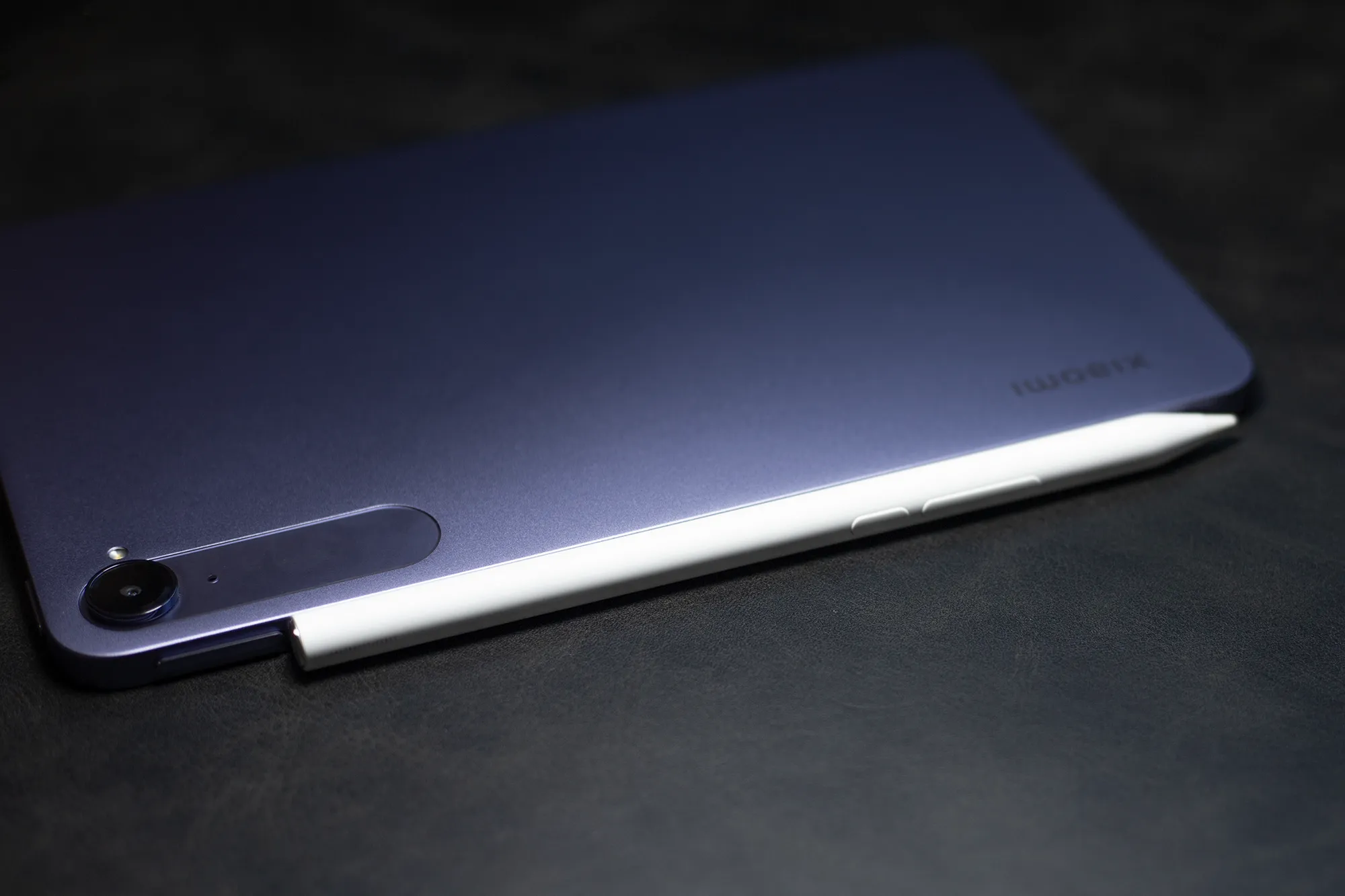 Xiaomi製タブレットのパープル色の背面に、白いスタイラスペンがマグネットで取り付けられている(または充電中の)クローズアップ写真。