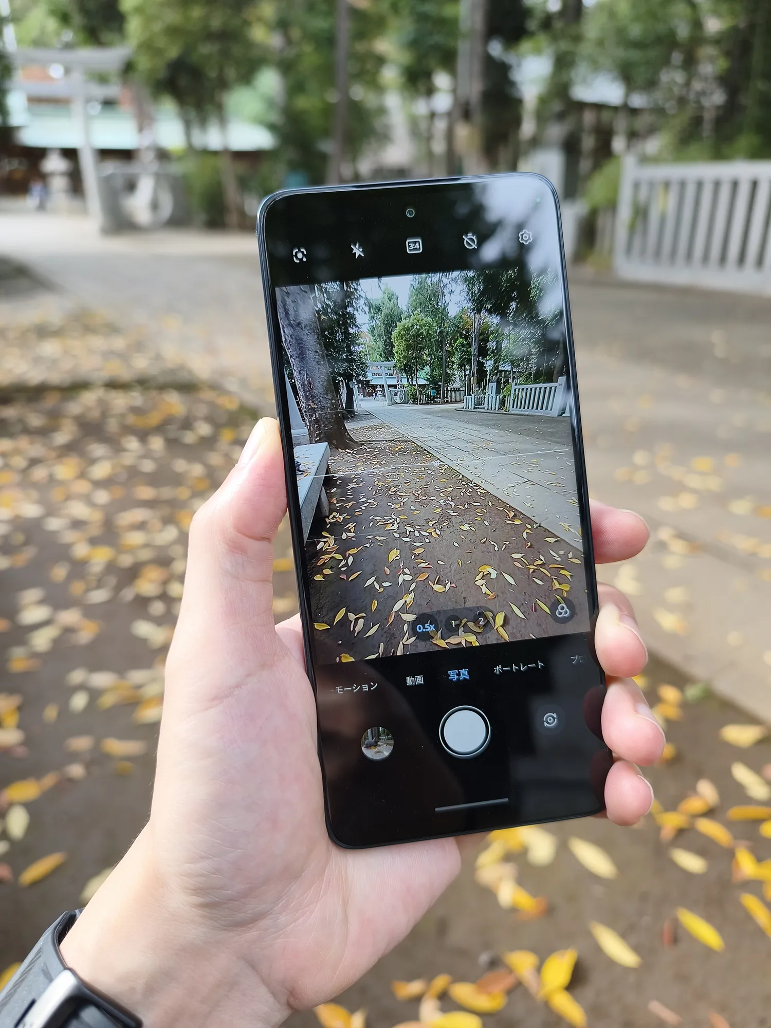 moto g66j 5Gのカメラアプリ画面のUI作例。落ち葉が散る参道をファインダー越しに写し、カメラの操作画面