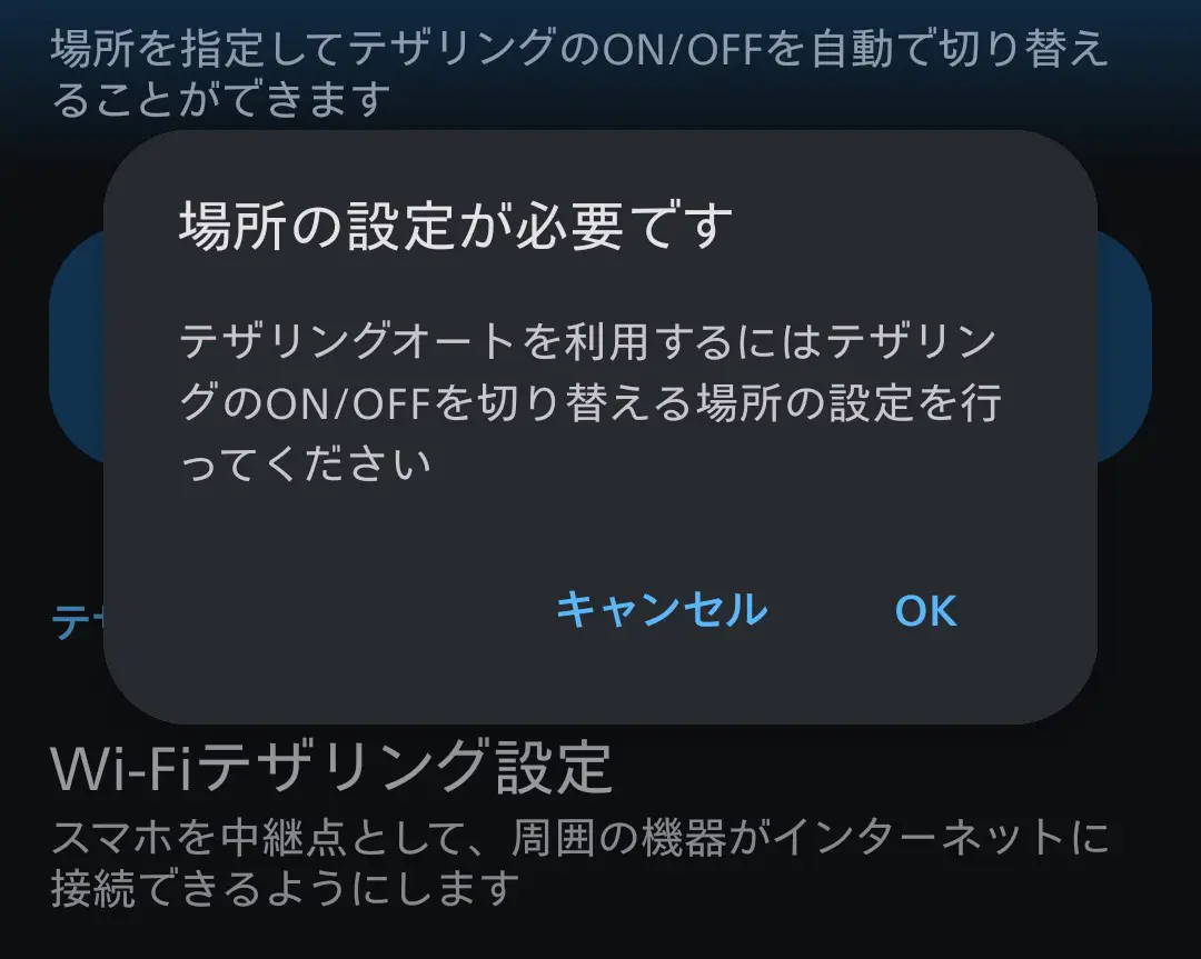 スマートフォンの「テザリングオート」機能設定時に表示されるダイアログ。「場所の設定が必要です」というメッセージが表示されており、テザリングのON/OFFを自動で切り替えるには、切り替えを行う場所の指定が必須であることを示す。テザリングの自動化に関するセットアップ手順や設定の重要性を伝える。