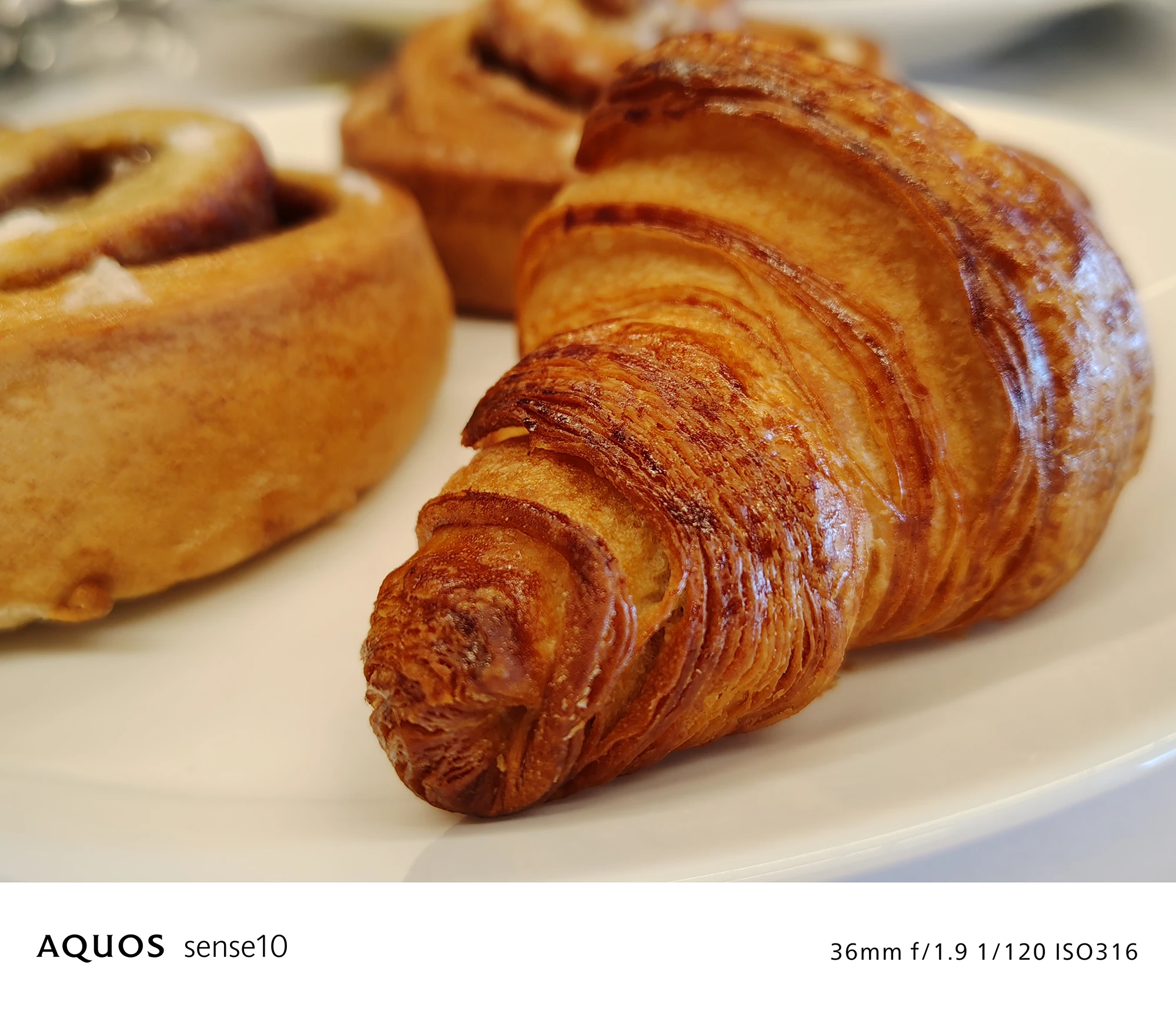 AQUOS sense10撮影サンプル：室内のクロワッサンのテーブルフォト（36mm f/1.9 ISO316）