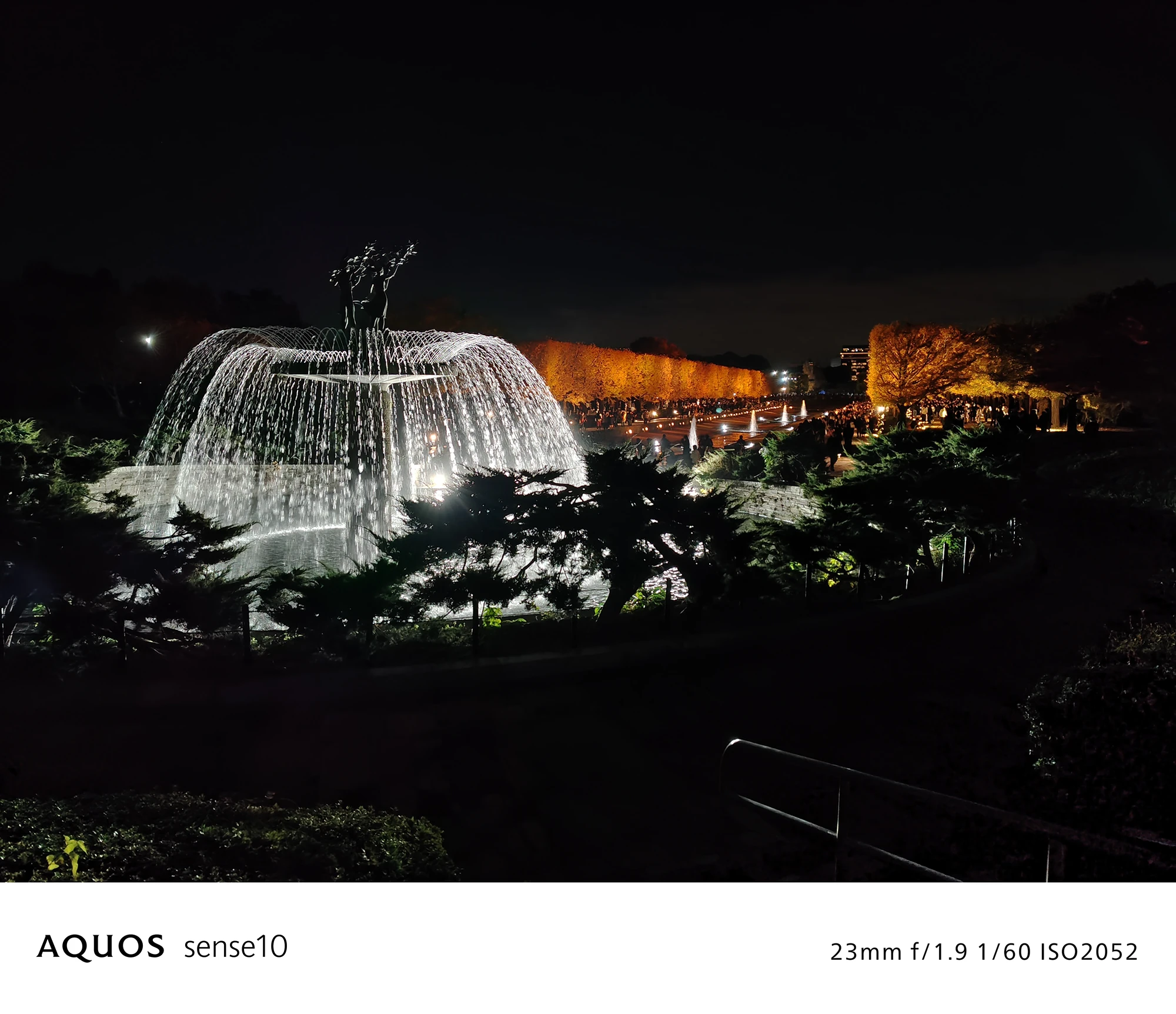 AQUOS sense10撮影サンプル：広角で捉えた**ライトアップされた噴水と像の夜景**（f/1.9 ISO2052）