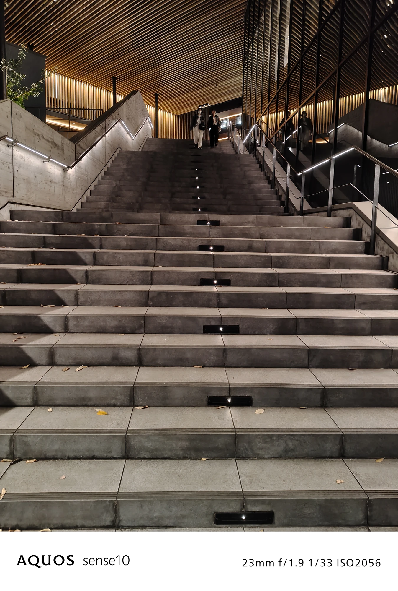 AQUOS sense10 撮影サンプル　夜間の階段と光の縞模様f/1.9 1/33 ISO2056