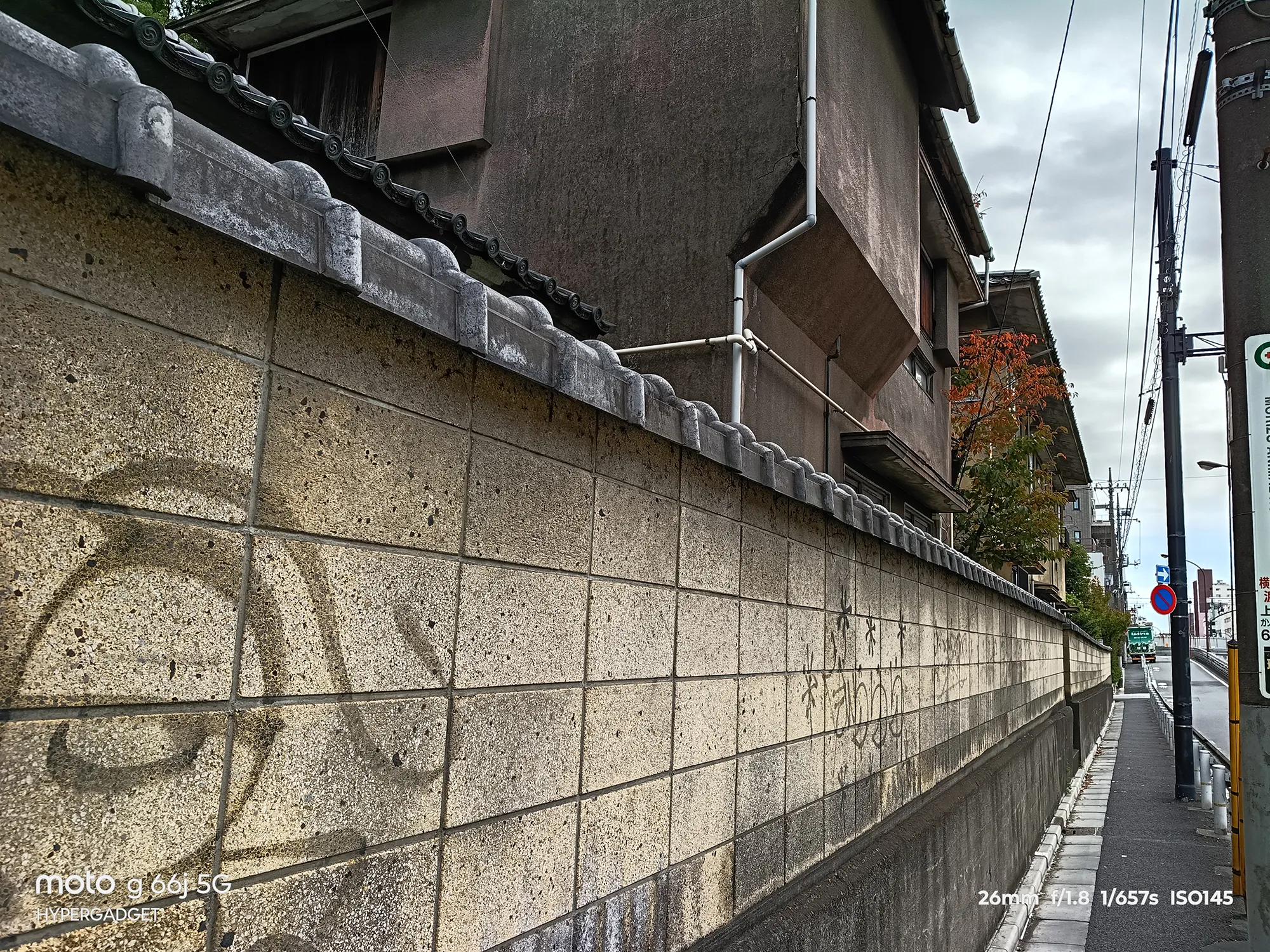moto g66j 5Gのカメラ作例：コンクリートブロックの塀と古い建物を近接撮影。壁面の質感とディテールの描写力をレビュー