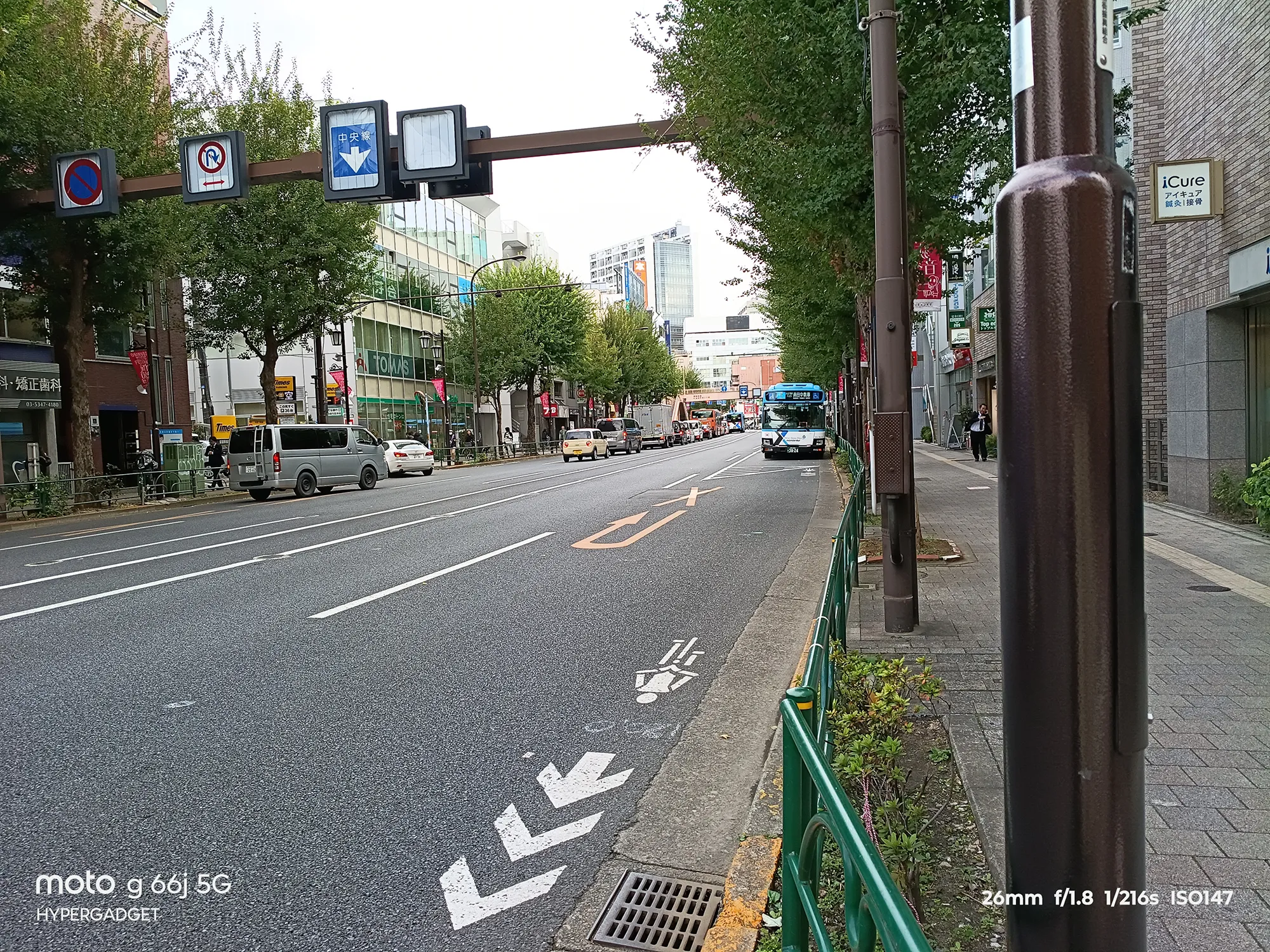 moto g66j 5Gのカメラ作例：電柱が手前にある都心部の道路。交通標識と奥行きのある町並みを撮影