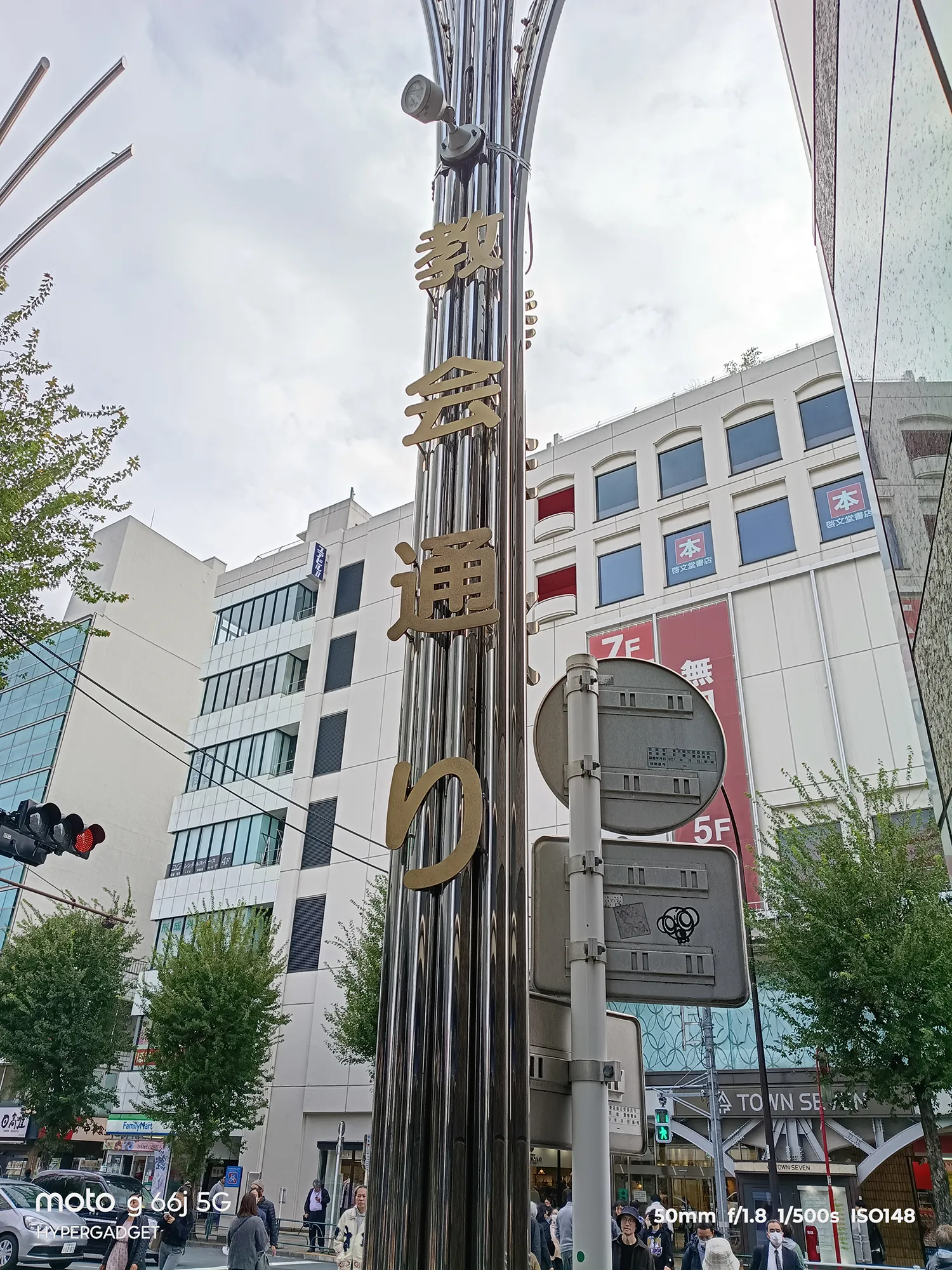 moto g66j 5Gのカメラ作例：タウンセブンの装飾的な街灯と、反射するビルの壁面を撮影。金属の光沢と看板文字の鮮明さをレビュー