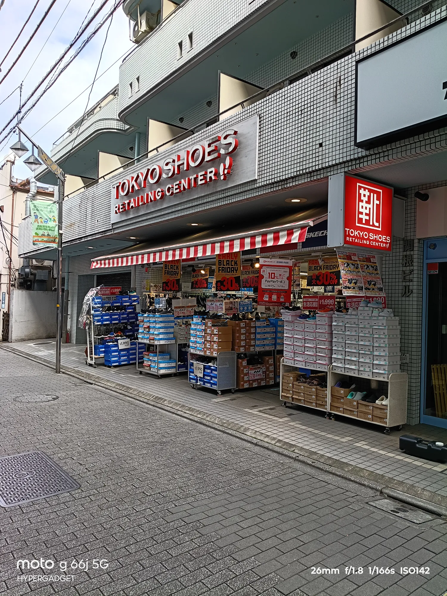 moto g66j 5Gのカメラ作例：TOKYO SHOESの店舗外観。店頭に並ぶ靴箱とセール看板の文字の可読性をレビュー