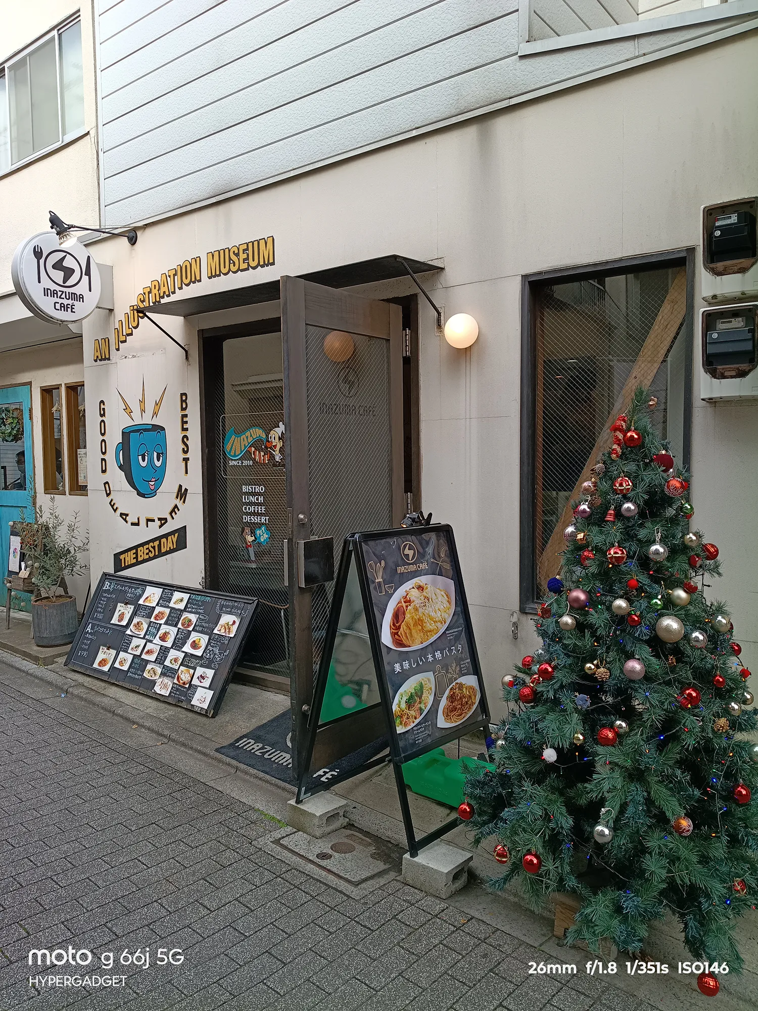 moto g66j 5Gのカメラ作例：INAZUMA CAFEの外観とクリスマスツリー。鮮やかな装飾とメニューの文字の可読性をレビュー