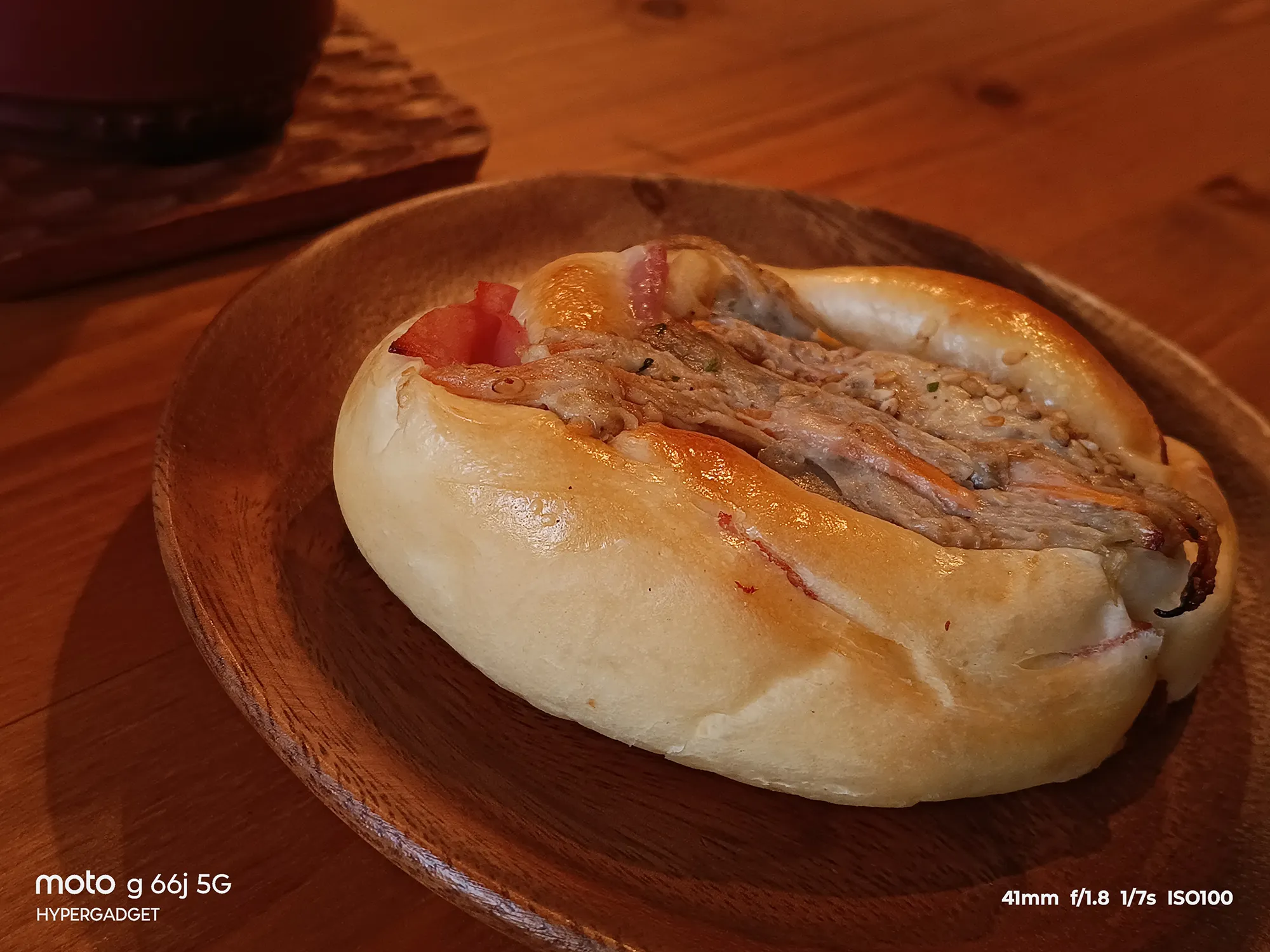 moto g66j 5Gのカメラ作例：木皿に載った惣菜パンをクローズアップ。パンの質感と具材のディテール、暖色系の色再現性をレビュー