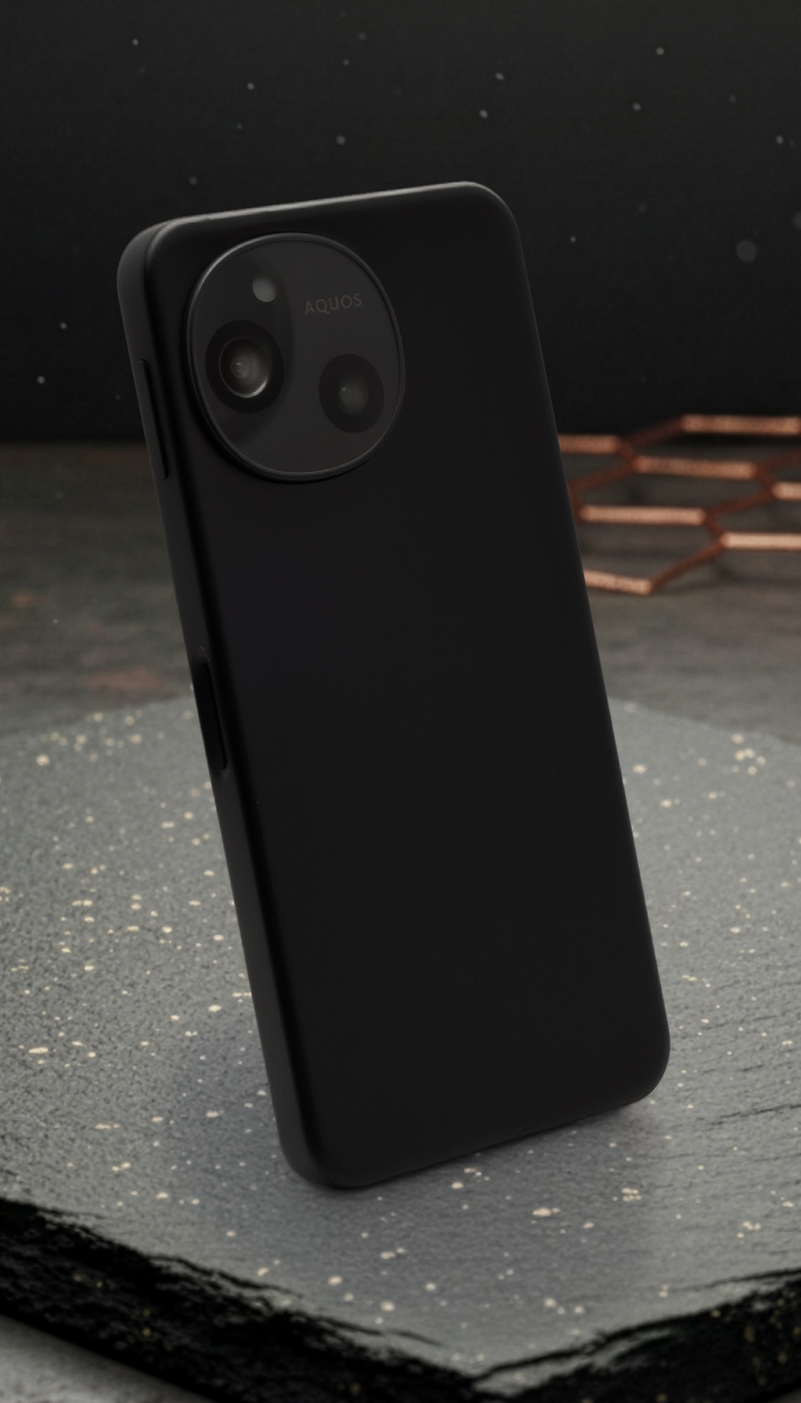 AQUOS sense10またはSH-M33のマットブラックの背面全体を映した製品写真。左上には円形のデュアルカメラモジュールと「AQUOS」ロゴが配置されている。本体の落ち着いたデザインと高い質感、そしてカメラユニットの存在感を強調。