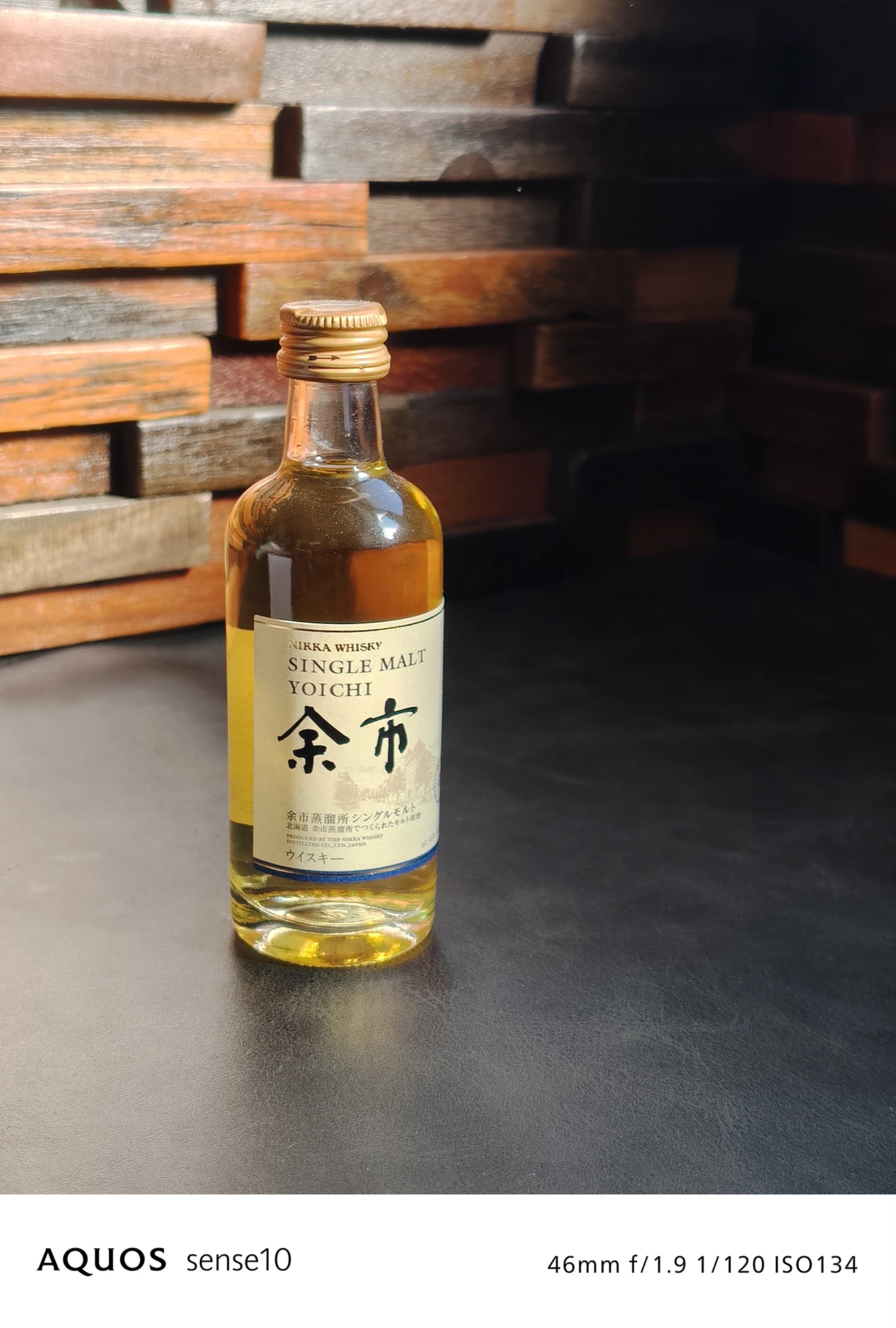AQUOS sense10による、余市シングルモルトウイスキーのミニボトル接写写真。46mm f/1.9 1/120 ISO134の撮影設定。ラベルやガラス瓶の質感を鮮明に描写し、AQUOS sense10の優れた静物・クローズアップ撮影能力を示すカメラサンプル。