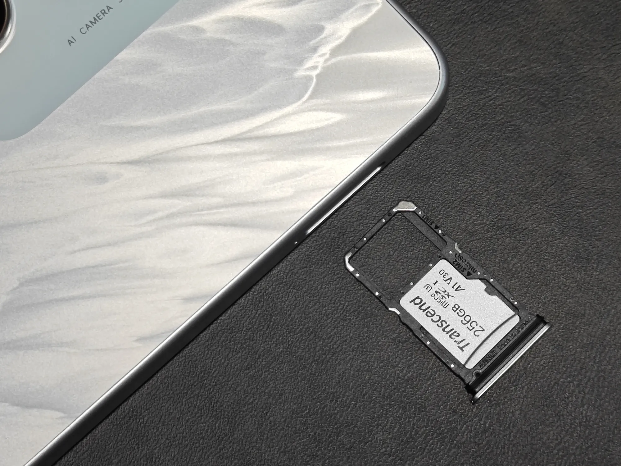 OPPO A5 5Gの本体側面から引き出されたSIMカード/microSDカードトレイ。トレイにはTranscend製の256GB V30 microSDカードが搭載されており、背面にはAI CAMERA SYSTEMの刻印が見える。