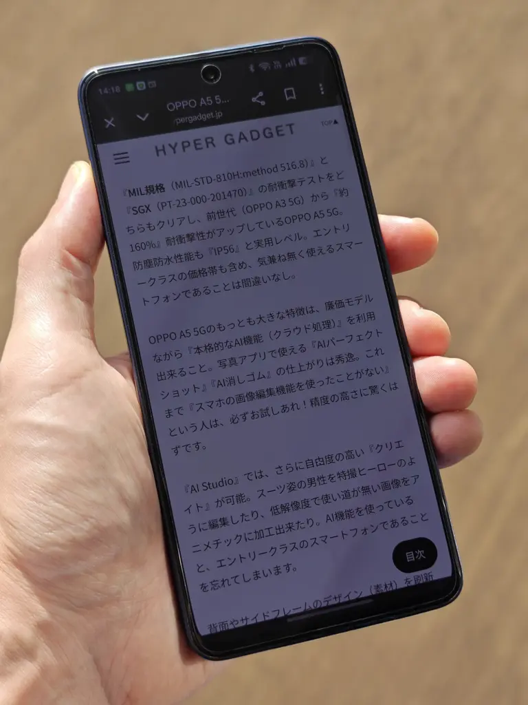 OPPO Reno13 Aを手に持ち、Webサイト「HYPER GADGET」のレビュー記事を閲覧している様子