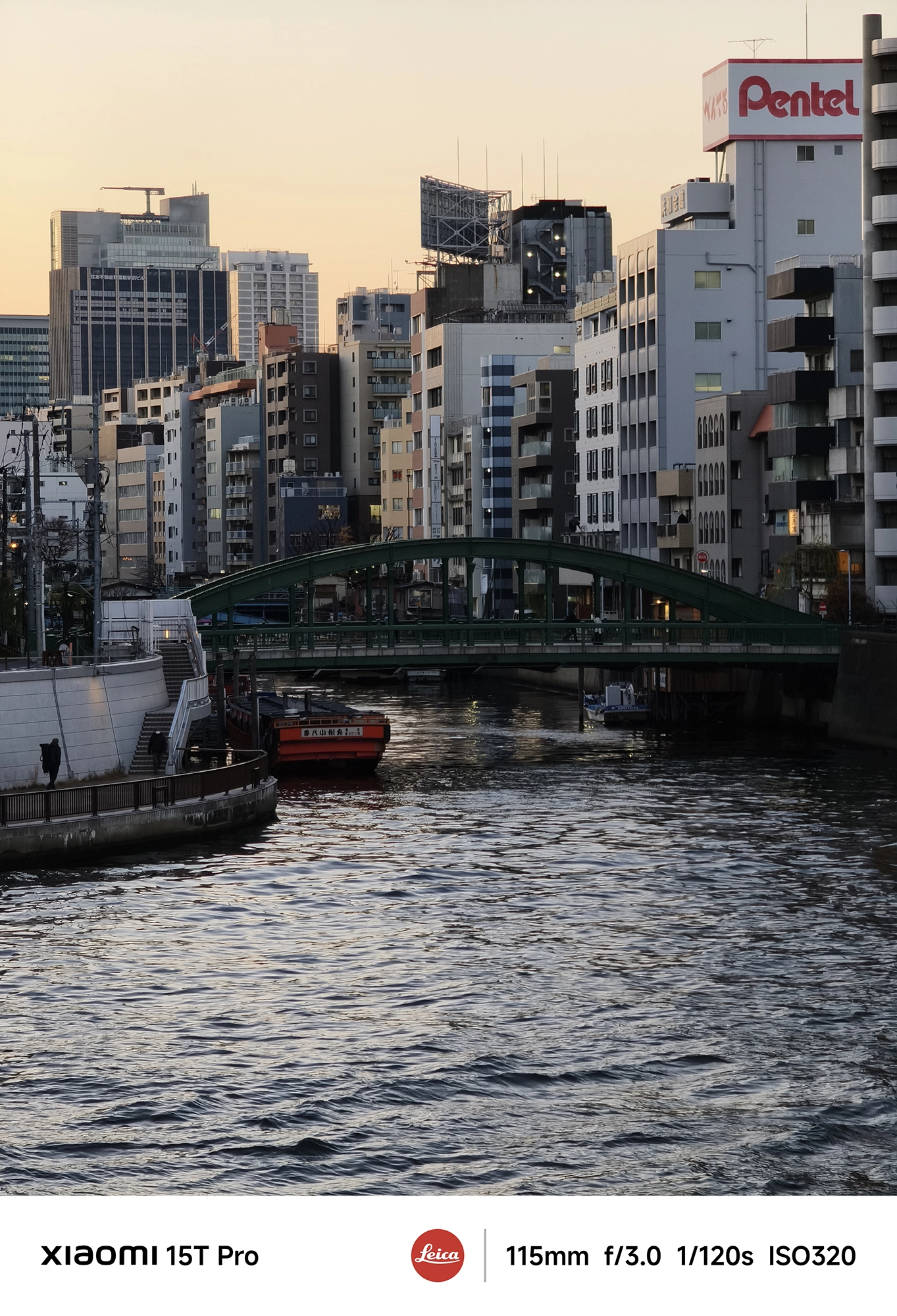 Xiaomi 15T Proの5倍望遠で撮影した都心の運河と緑のアーチ橋、夕方の街並み