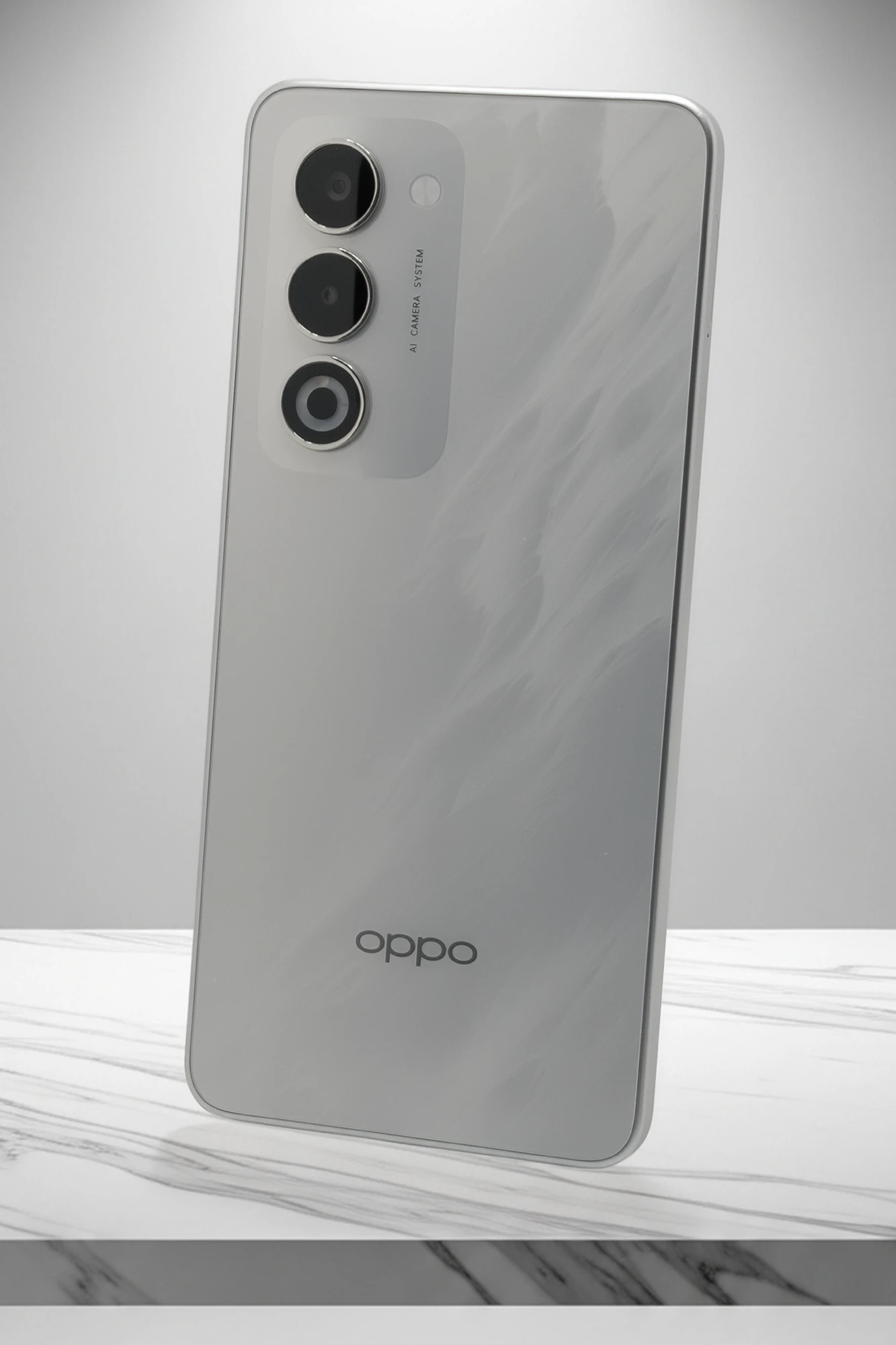 OPPO A5 5Gのスタジオ写真。垂直に配置されたカメラモジュールに「AI CAMERA SYSTEM」と刻印され、底面にはOPPOロゴがある。