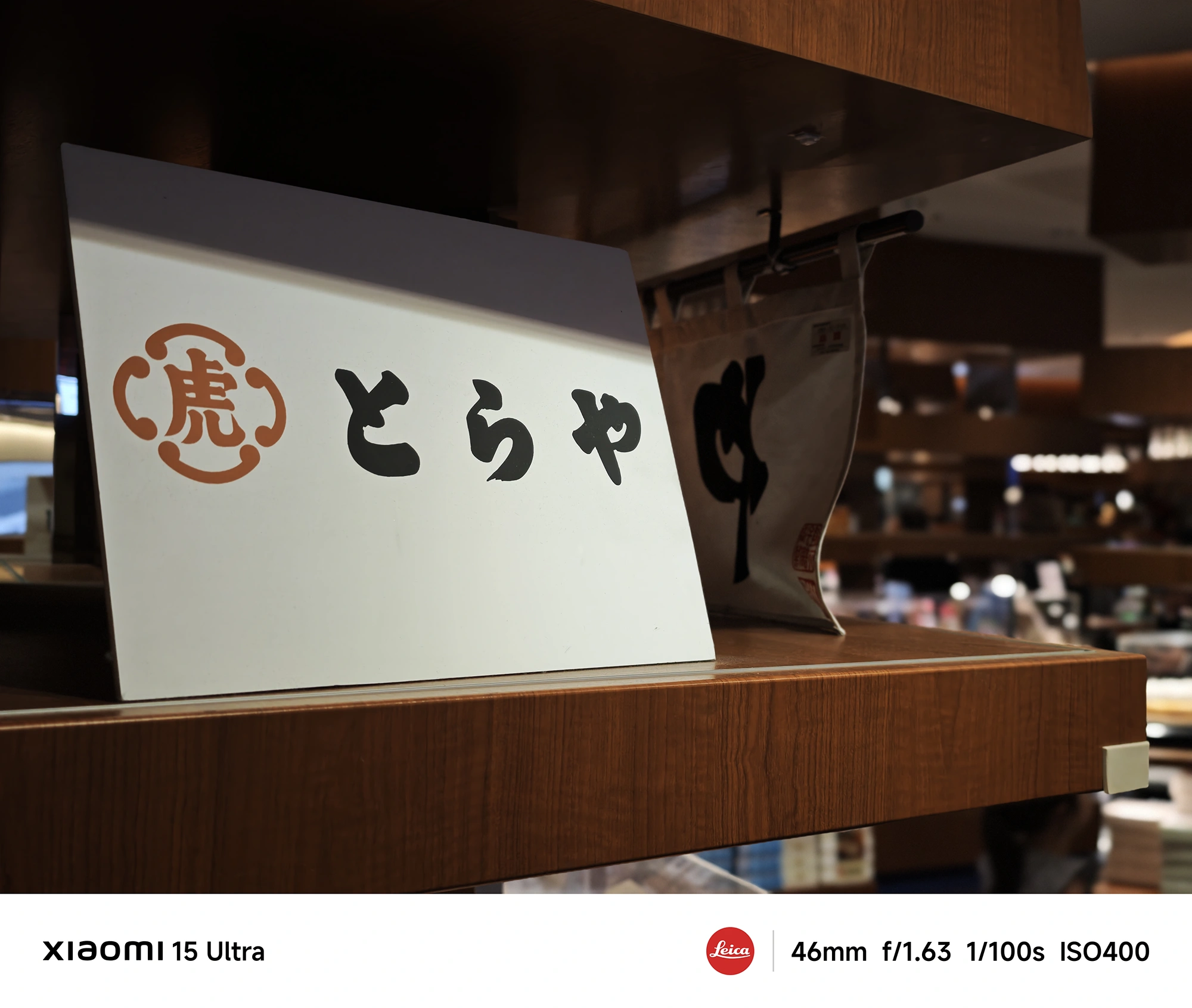 Xiaomi 15 Ultra作例:「とらや」看板のクローズアップ、店内照明と木目の質感を描写(46mm)