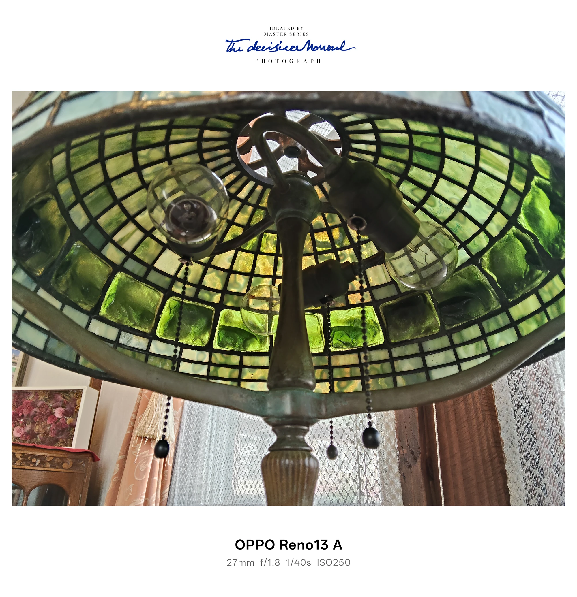 OPPO Reno13 Aで撮影した、緑のステンドグラス調シェードの天井照明を下から見上げたカット（電球と格子模様）