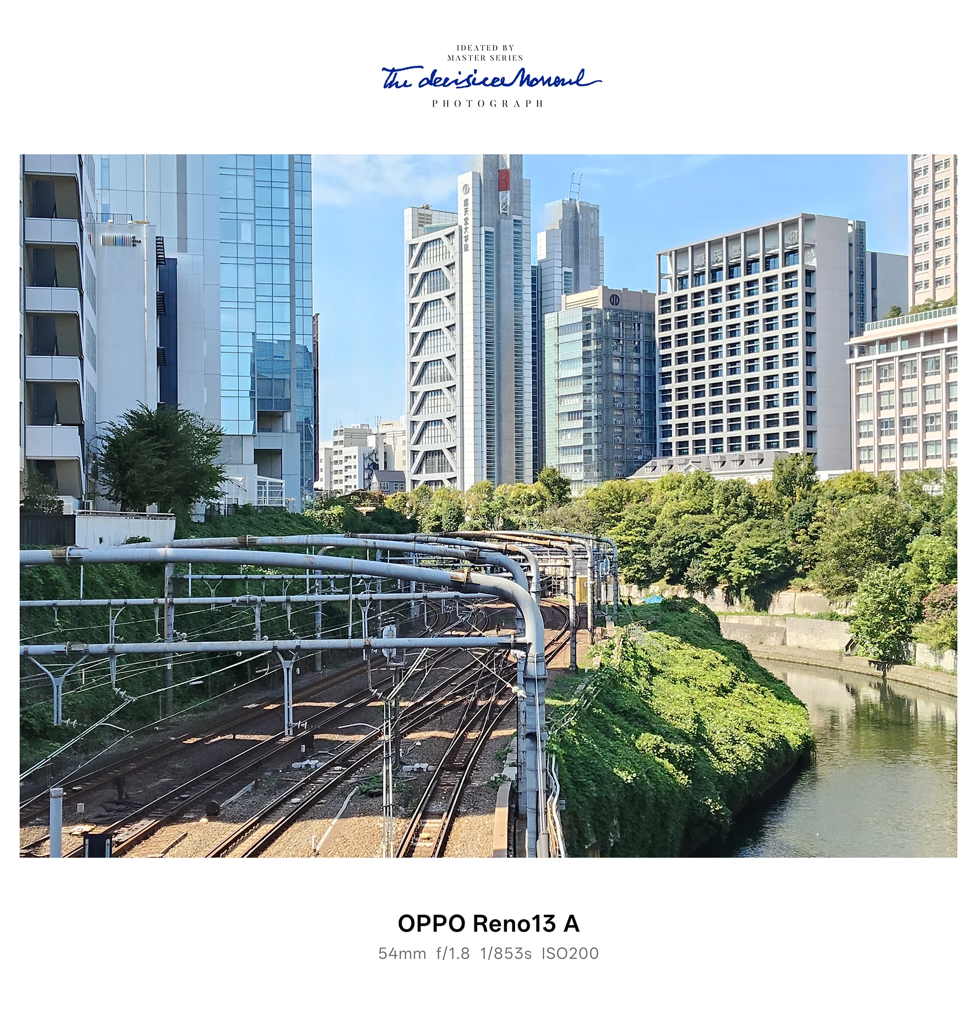 OPPO Reno13 A 作例：川沿いをカーブする線路と高層ビル群の都市風景