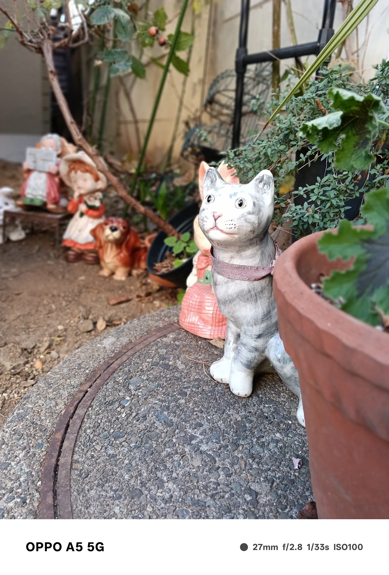 OPPO A5 5Gで撮影した猫の陶器のオブジェ。前景の置物がシャープに写り、背後の人形が柔らかくぼける立体的な写真
