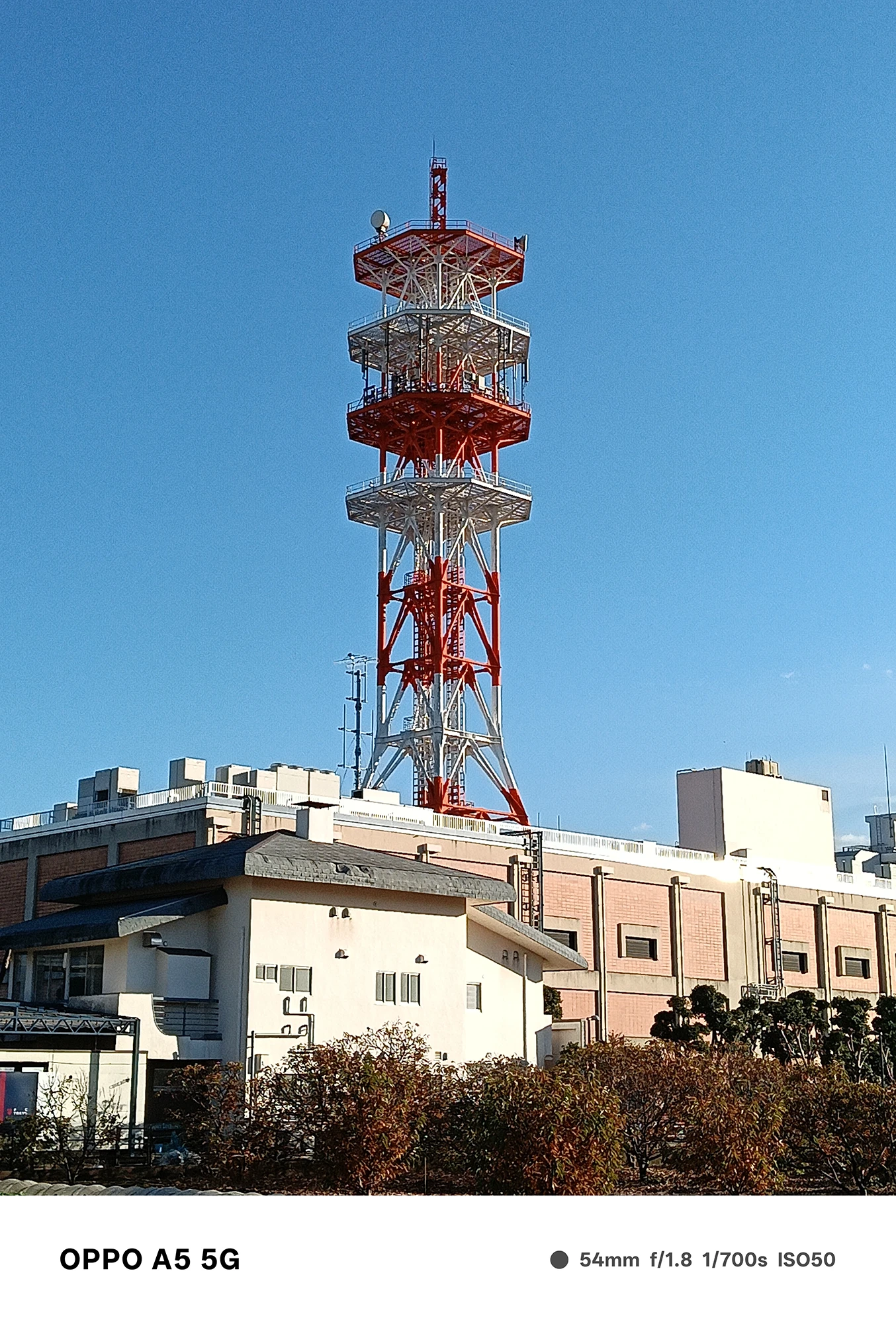 OPPO A5 5Gで撮影した通信塔の中望遠ショット。赤白の鉄骨構造が鮮明に写り、空の青とのコントラストが際立つ作例