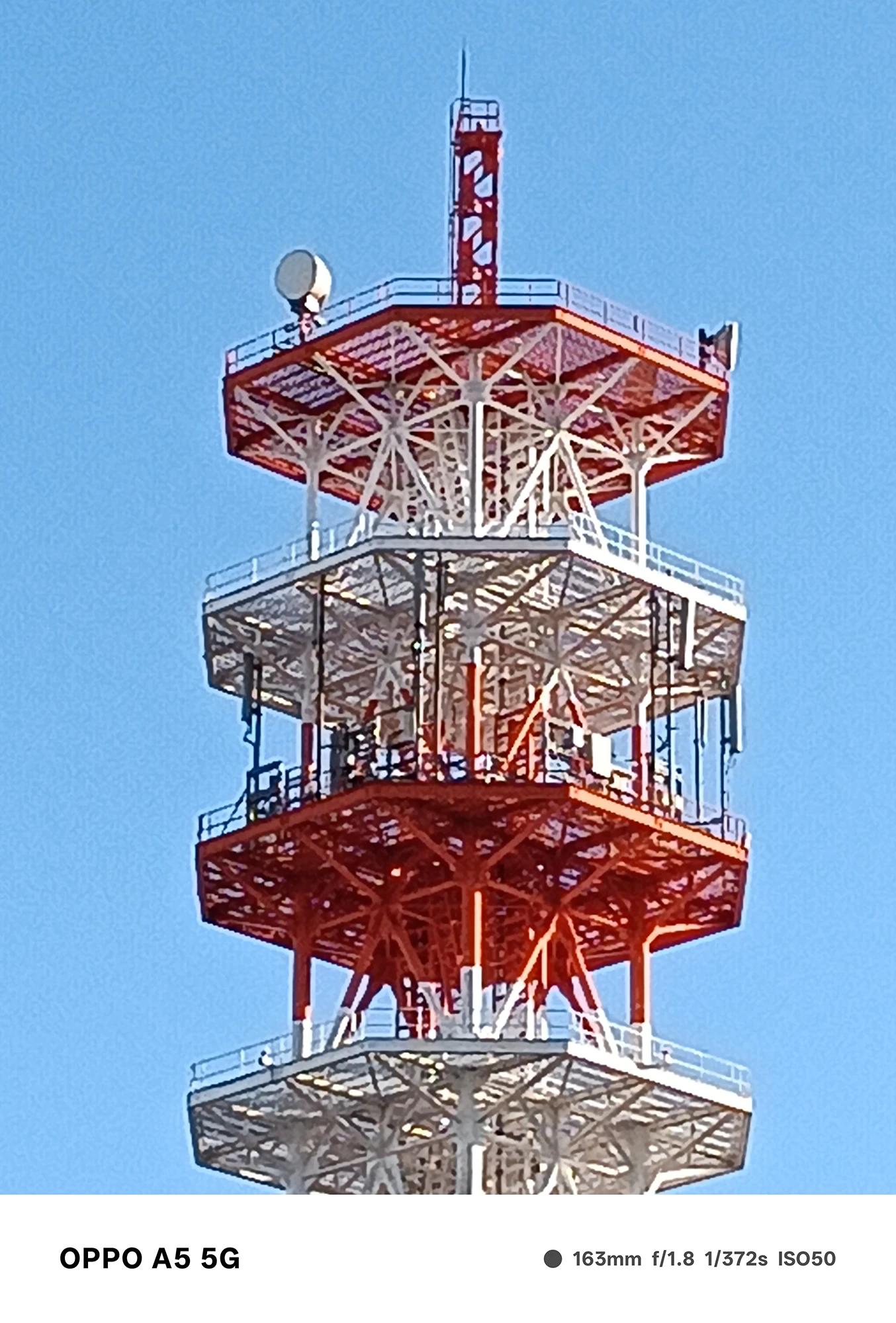 OPPO A5 5Gのズームで撮影した通信塔の高倍率クローズアップ。赤白の鉄骨や設備の細かい構造が描写された作例