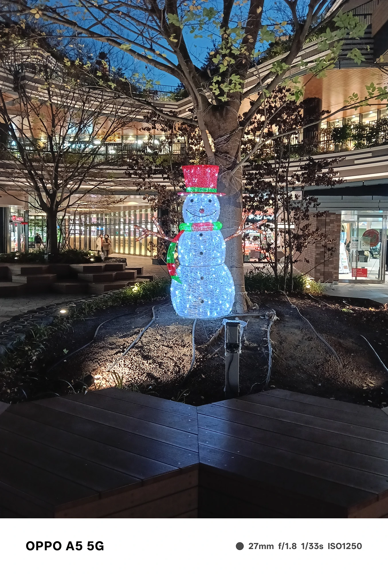 OPPO A5 5Gで撮影した雪だるまのイルミネーション。青白く発光する装飾と背景の商業施設が夜の雰囲気を鮮やかに描写した夜景写真