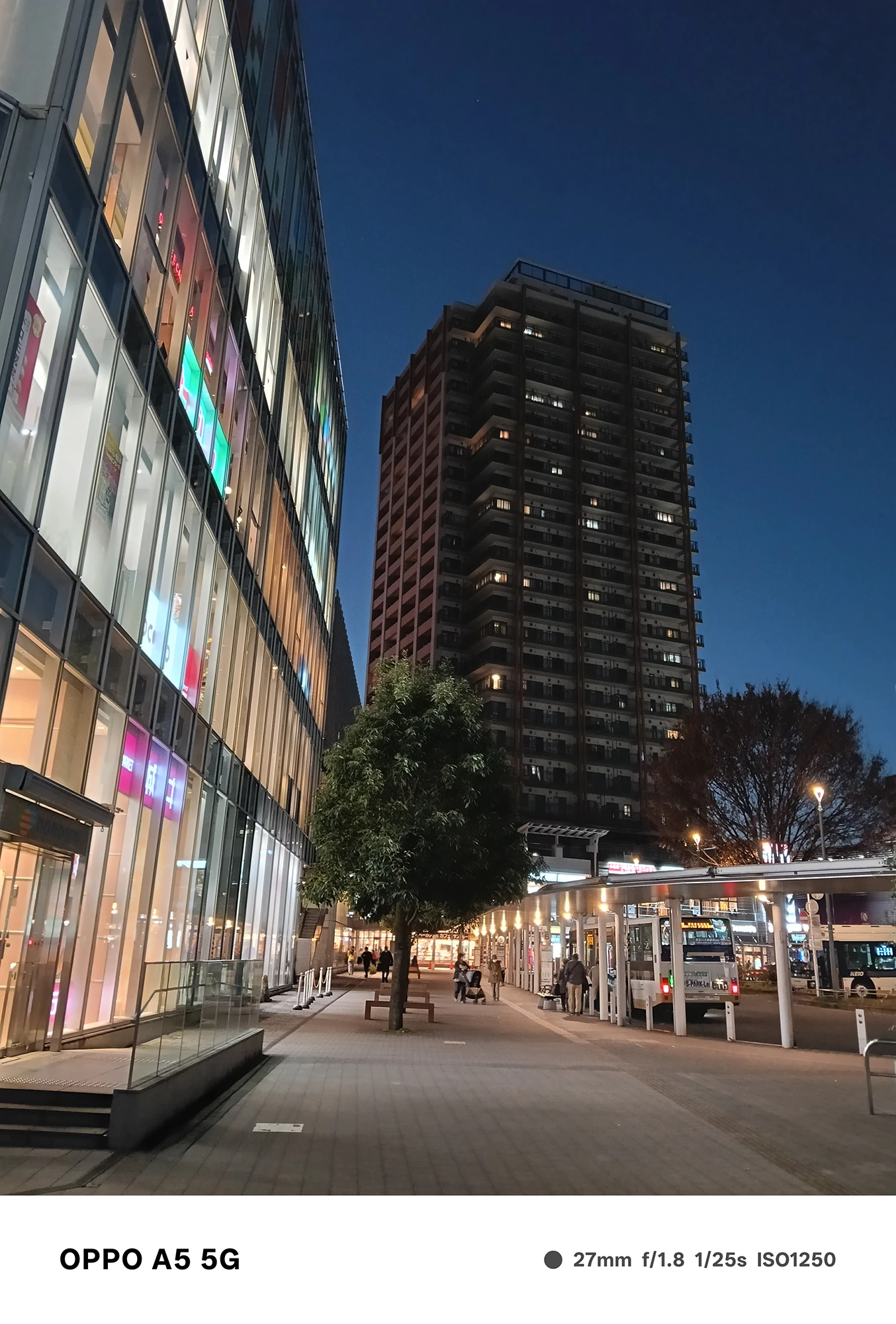 OPPO A5 5Gで撮影した高層マンションと駅前通りの夜景。群青色の空とビルの光、街路のにぎわいをクリアに表現した写真