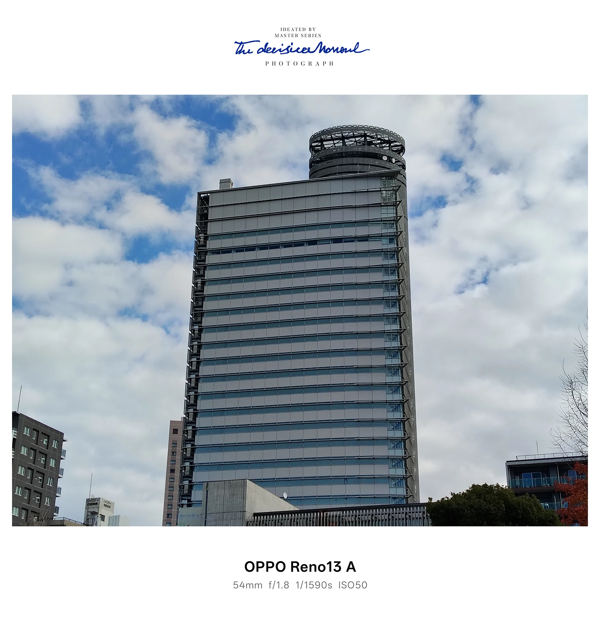 OPPO Reno13 A 作例：青空と雲を背景にそびえるガラス張りの高層建築